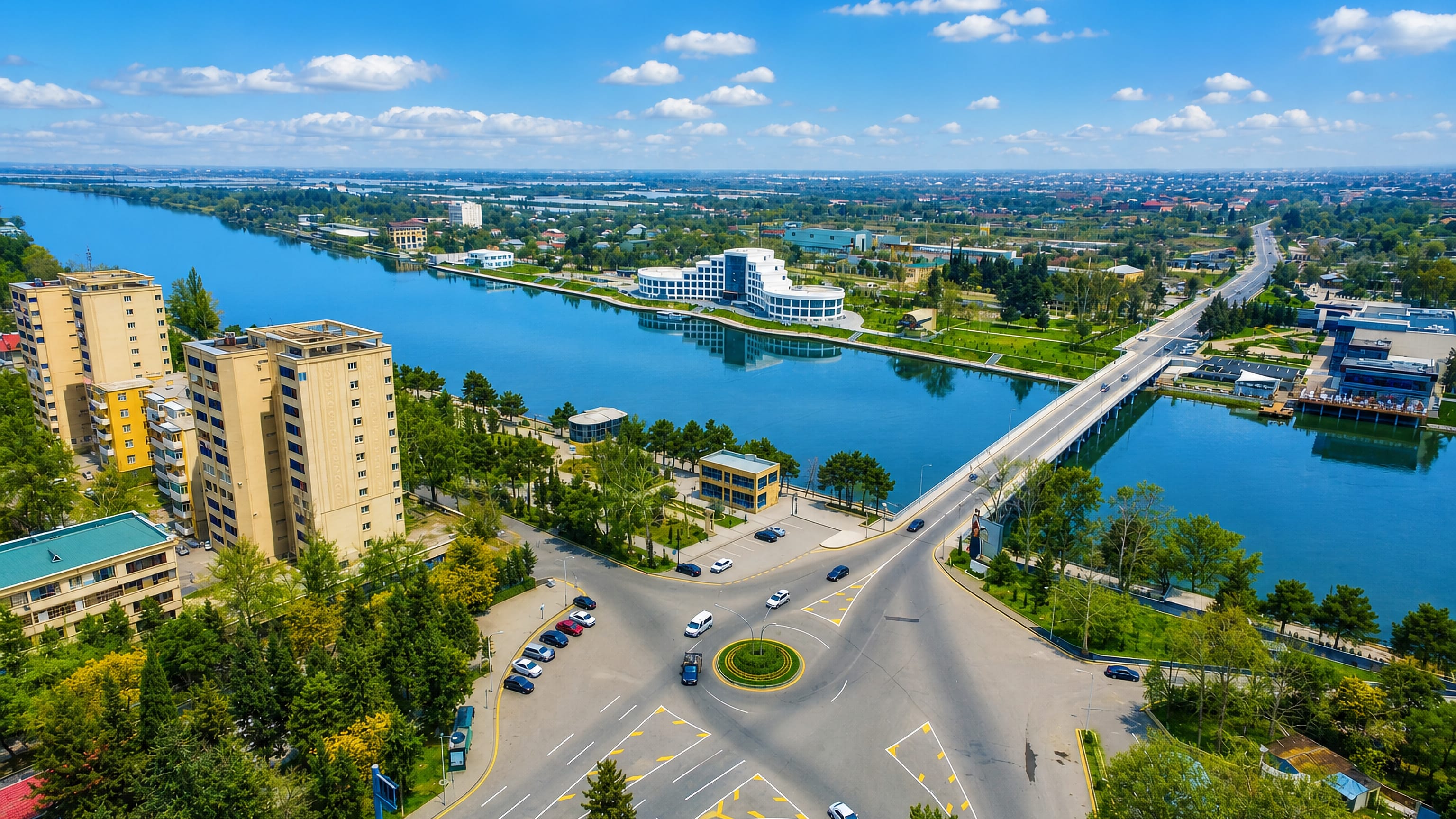 Mingachevir, Azerbaijan, with the Kura river, its road bridge, tower blocks and riverside roundabout.