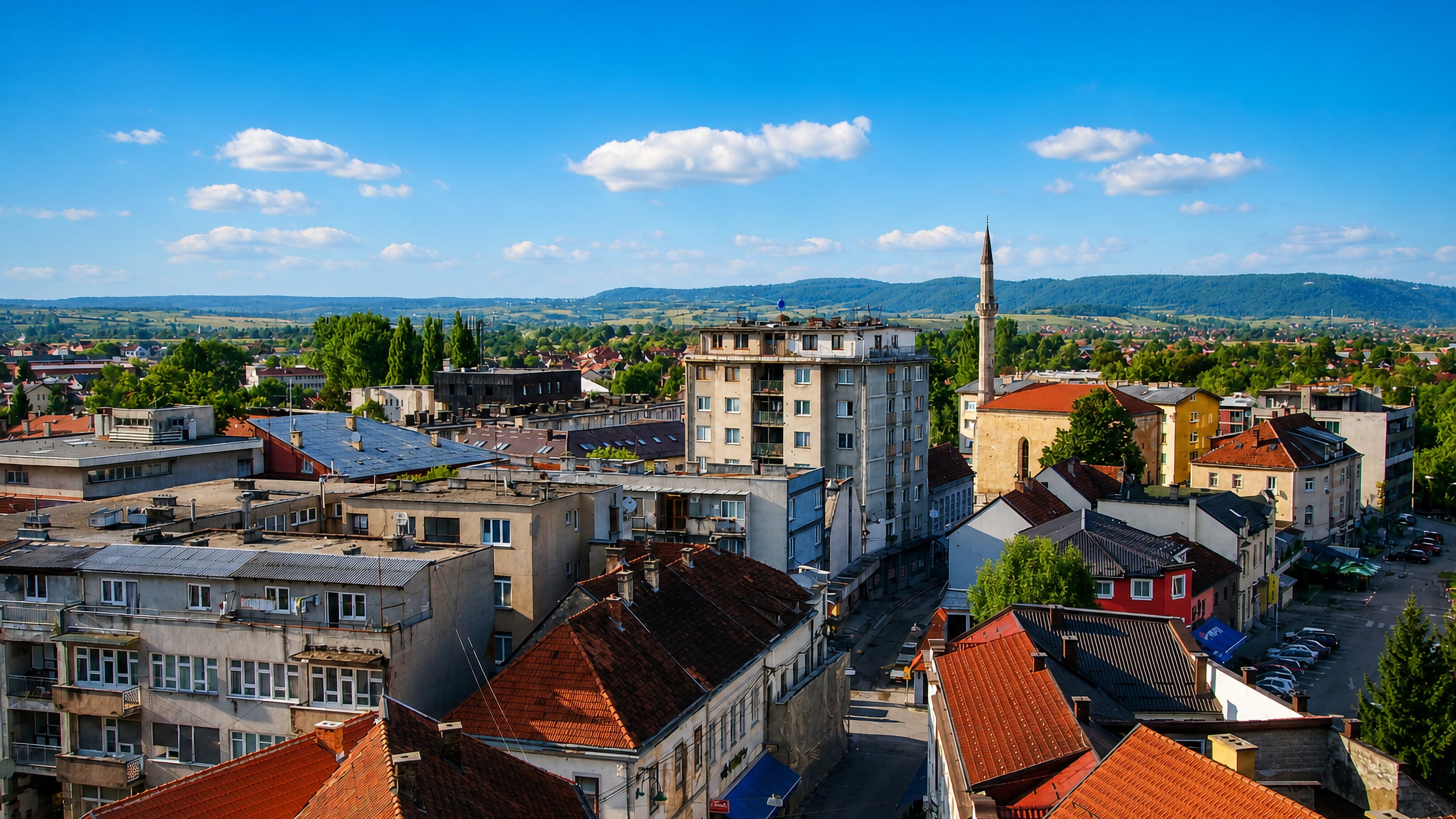 Red-tiled roofs, mid-century apartment blocks and a slender mosque minaret in Bihać, Bosnia and Herzegovina.