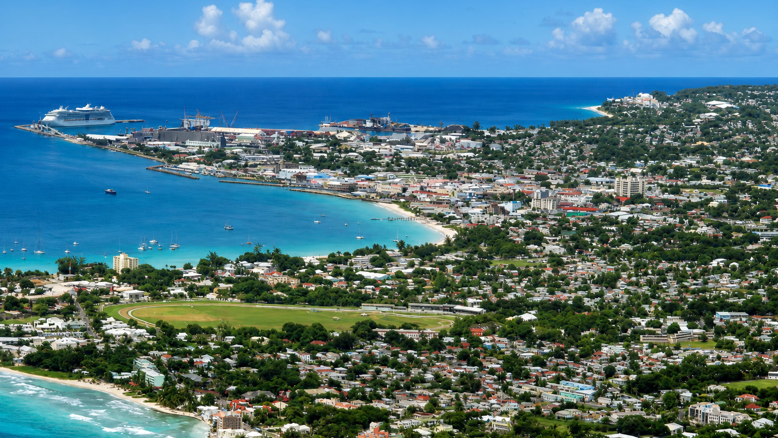 Aerial view of Bridgetown, Barbados, with Carlisle Bay's turquoise water, the cruise harbour and Garrison Savannah green.