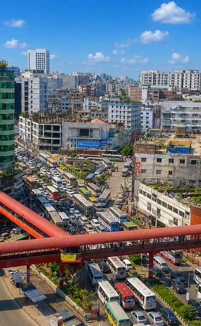Busy Farmgate intersection in Dhaka with its red pedestrian overpass, dense traffic and city buses