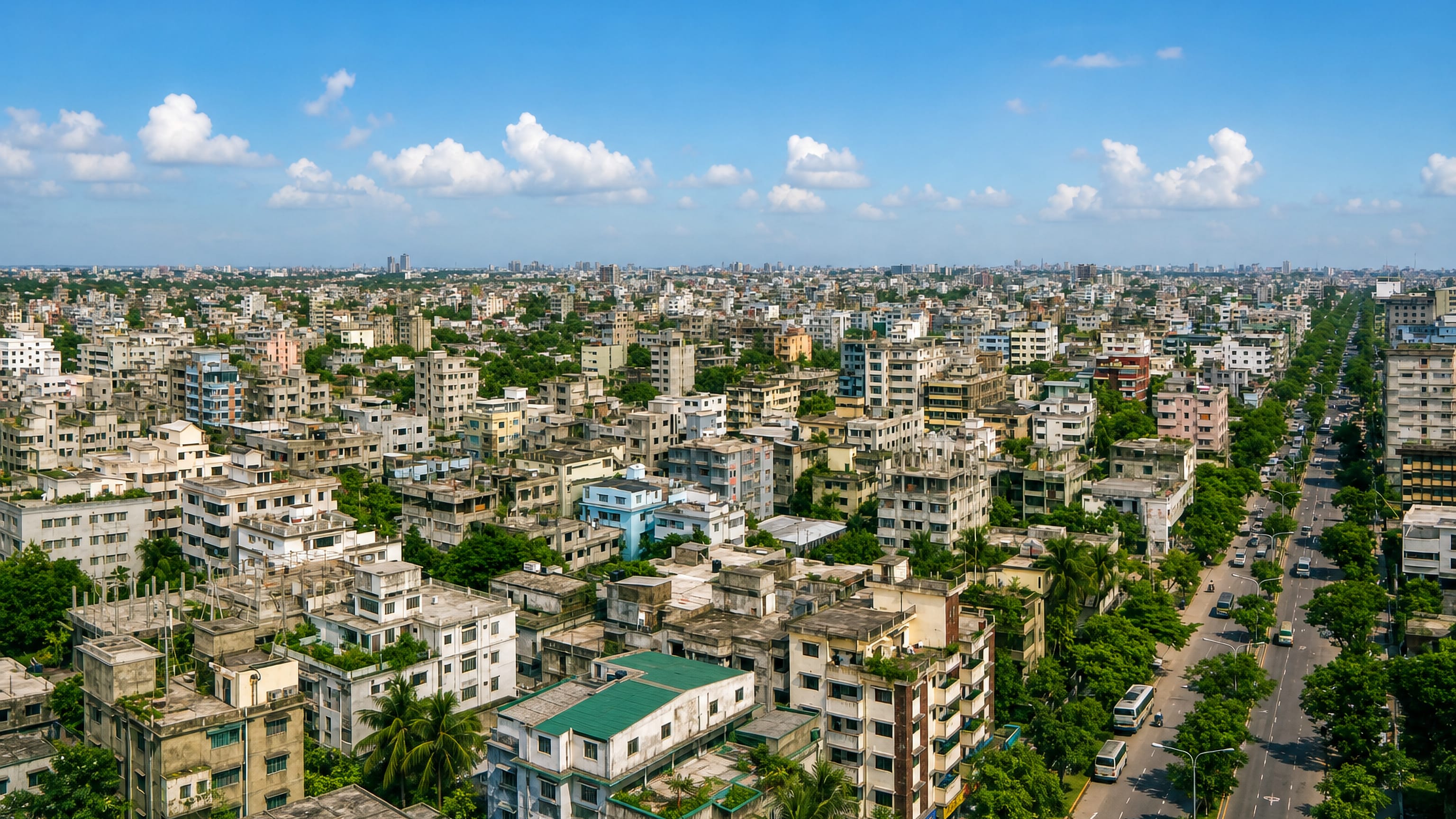 Dense mid-rise blocks and a broad tree-lined avenue across Pallabi in Mirpur, Dhaka.