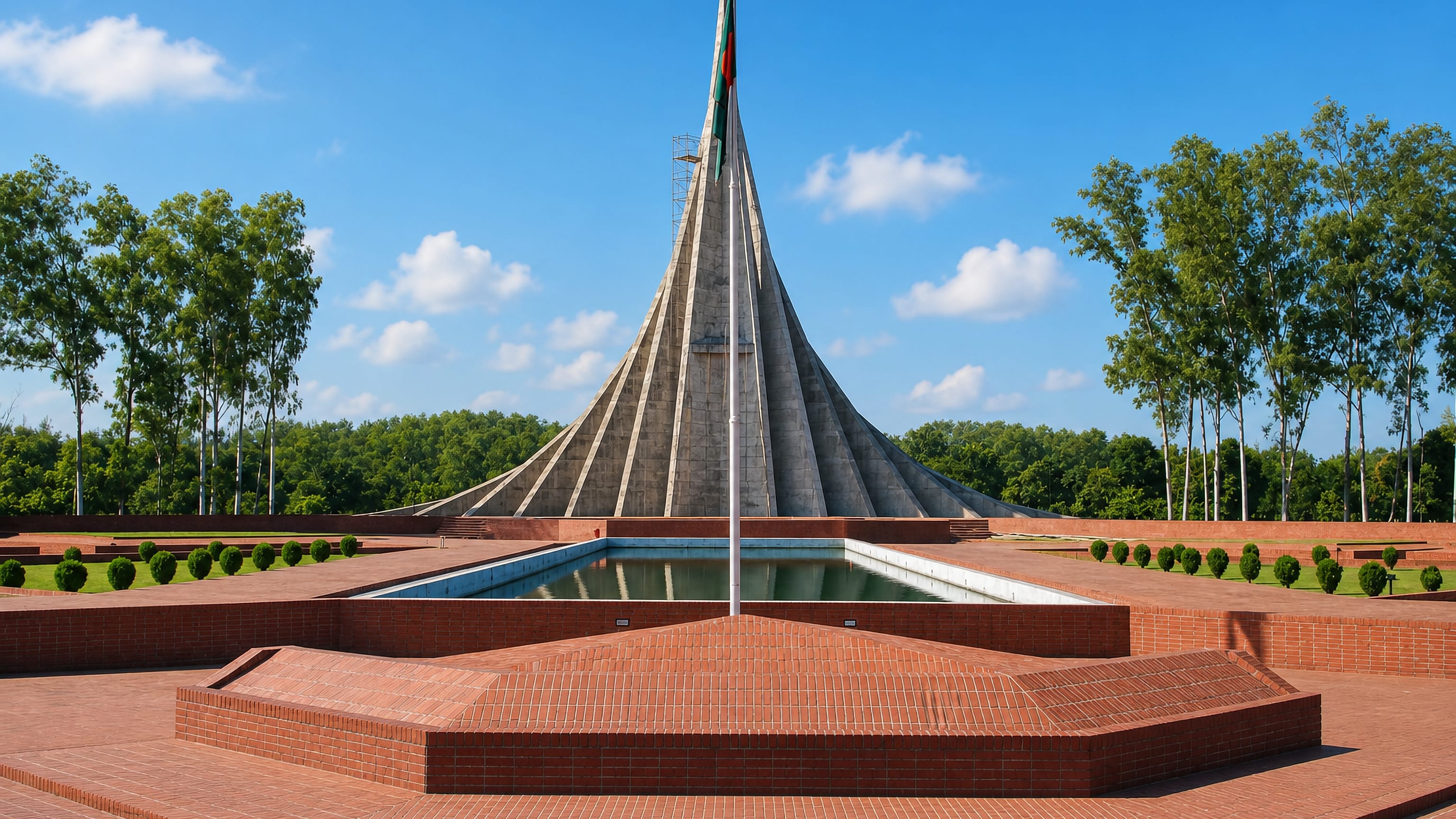 The tapered concrete National Martyrs' Memorial and its reflecting pool on a brick plaza in Savar, Bangladesh.