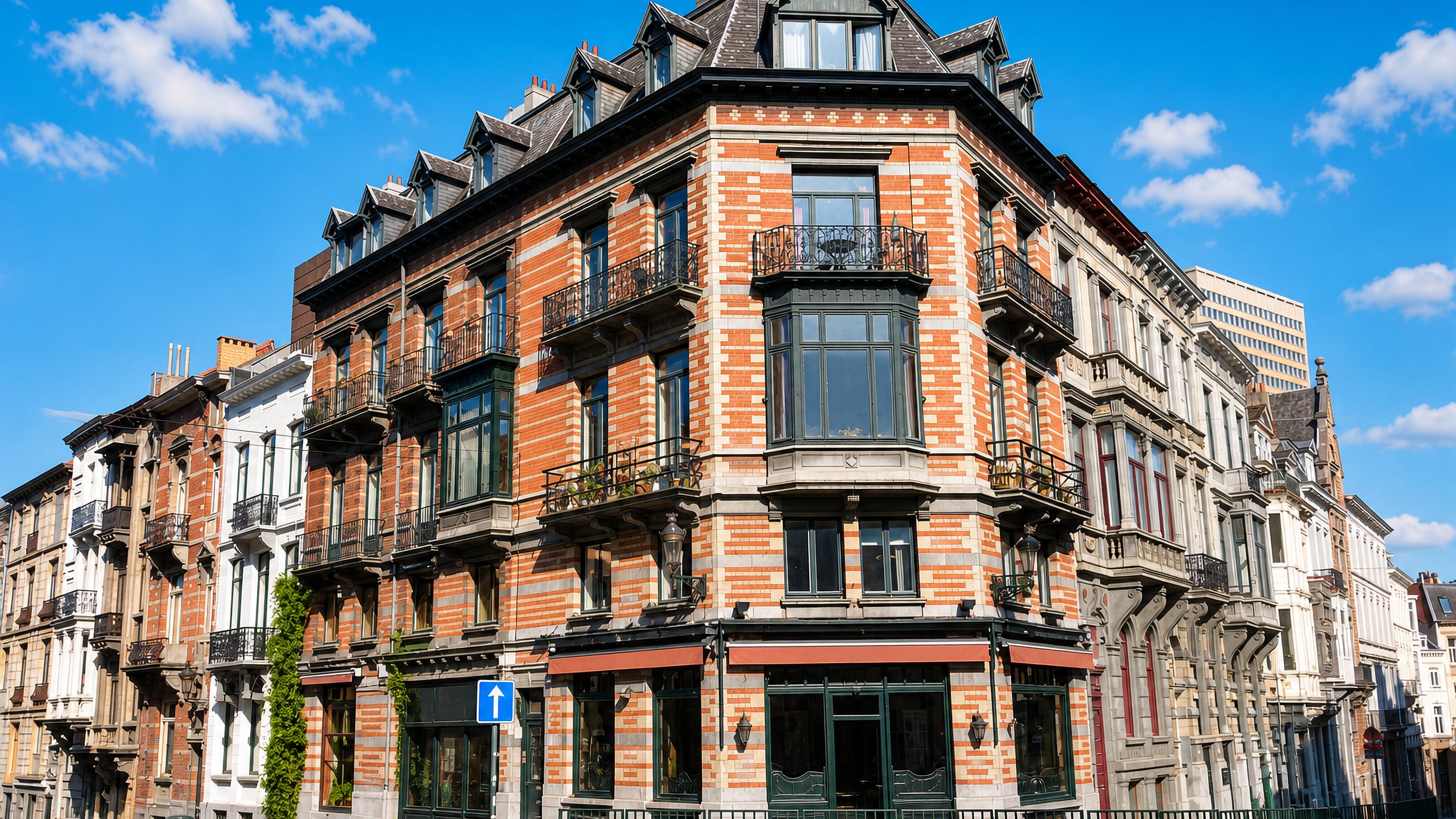 Ornate brick-and-stone corner townhouse on a cobbled street in the Sablon quarter, Brussels.