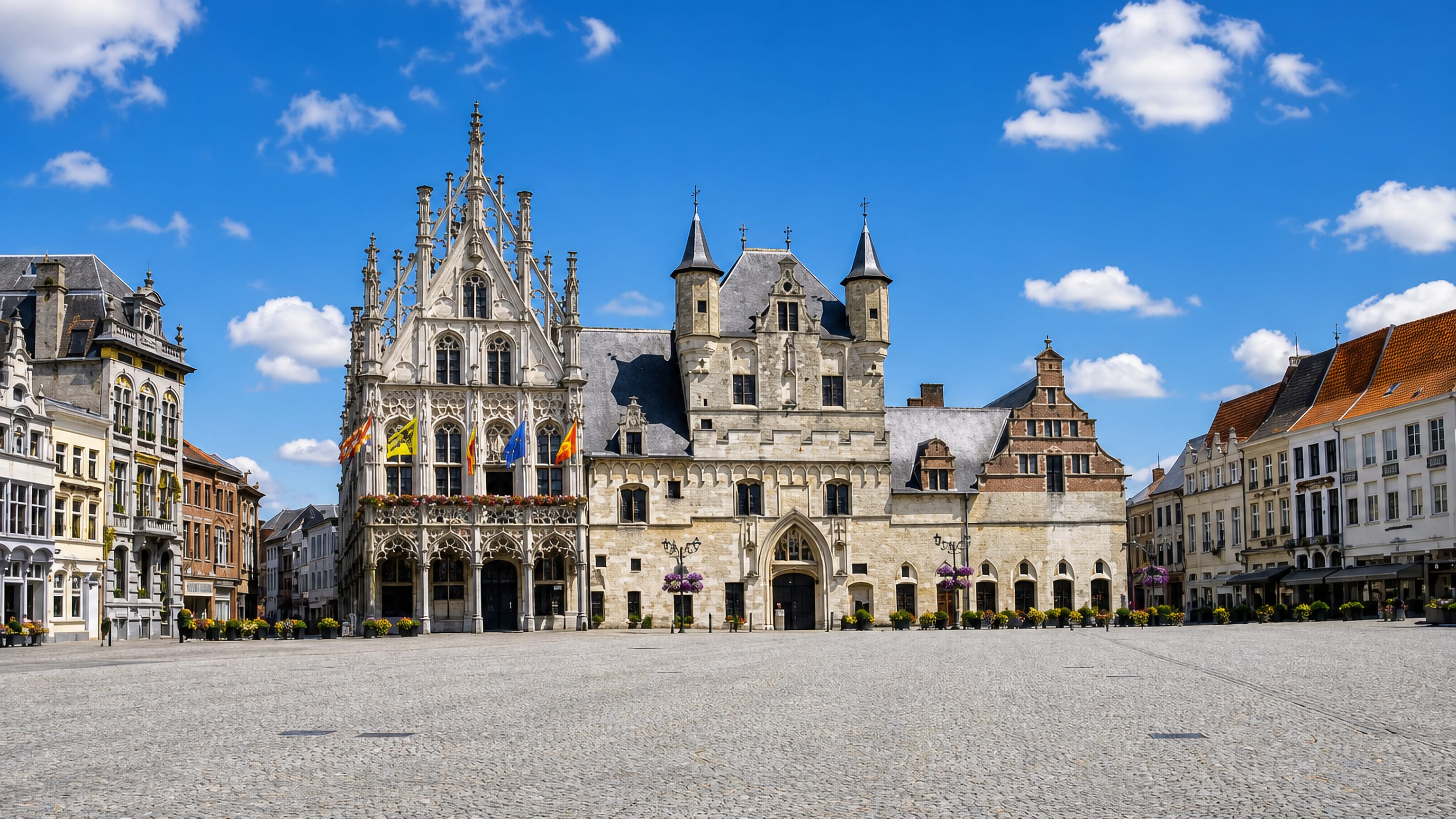 Mechelen's Grote Markt with the Gothic city hall and Cloth Hall facades facing the empty cobbled square.