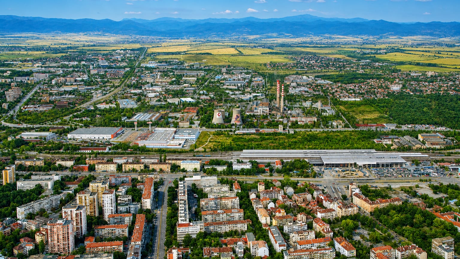 Aerial view of Sofia's Banishora district with rail yards and low-rise blocks on the plain