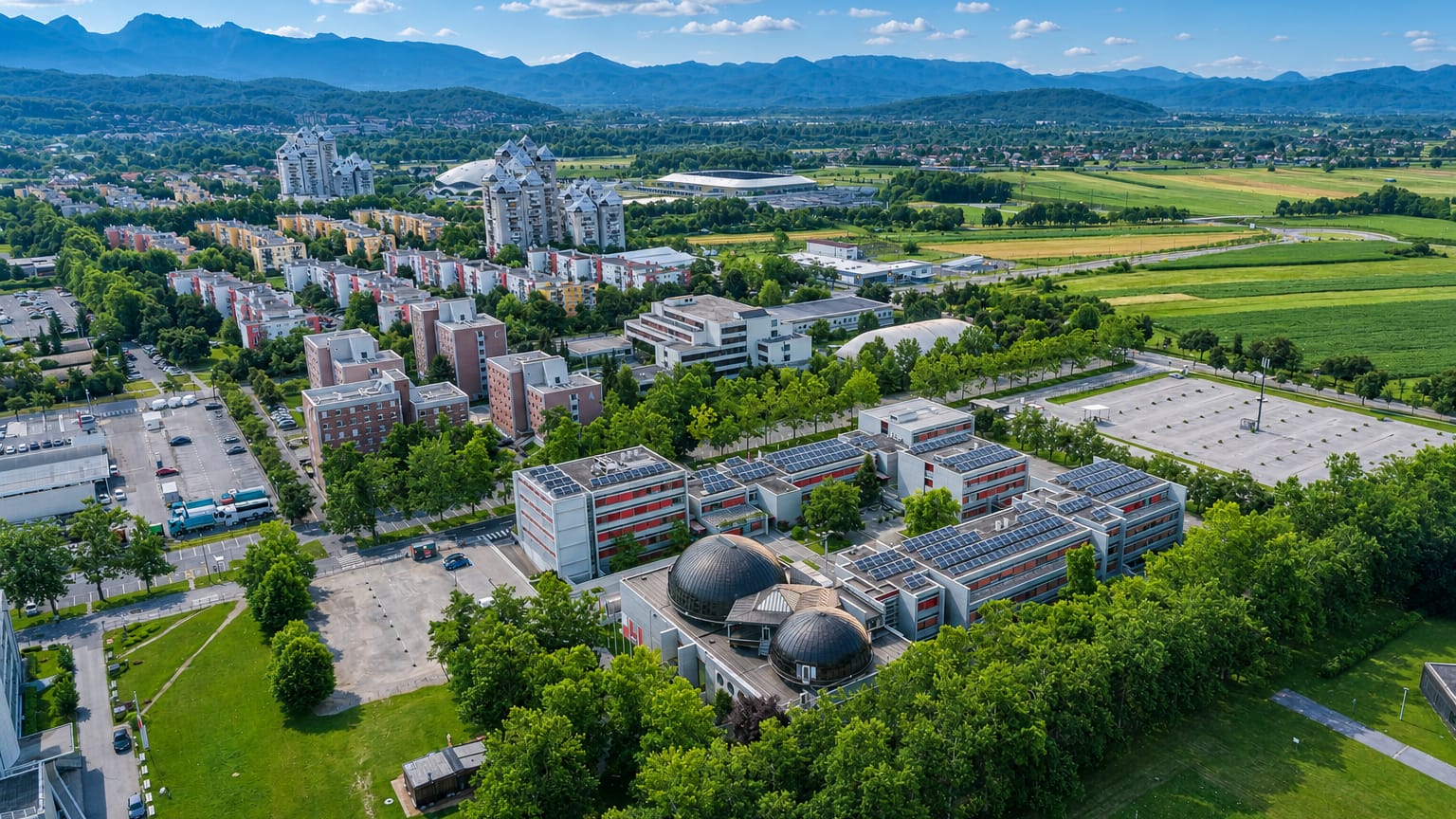 Aerial view of apartment blocks and green spaces in Sofia's Fakulteta district below mountains