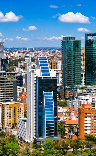 Santa Cruz de la Sierra's modern skyline of glass high-rise towers above tree-lined streets on the lowland plains.
