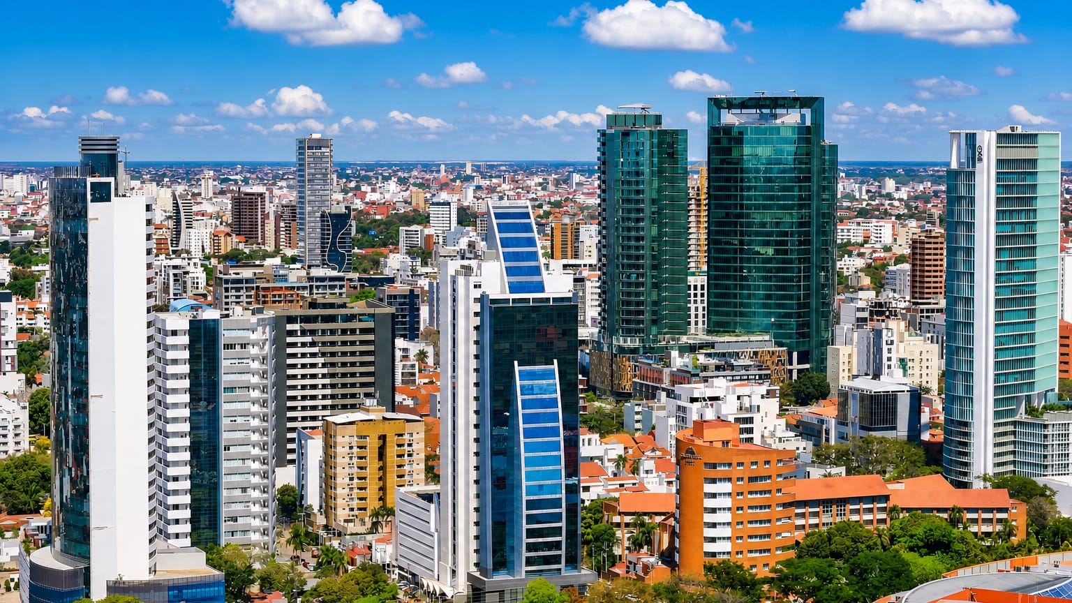 Santa Cruz de la Sierra's modern skyline of glass high-rise towers above tree-lined streets on the lowland plains.