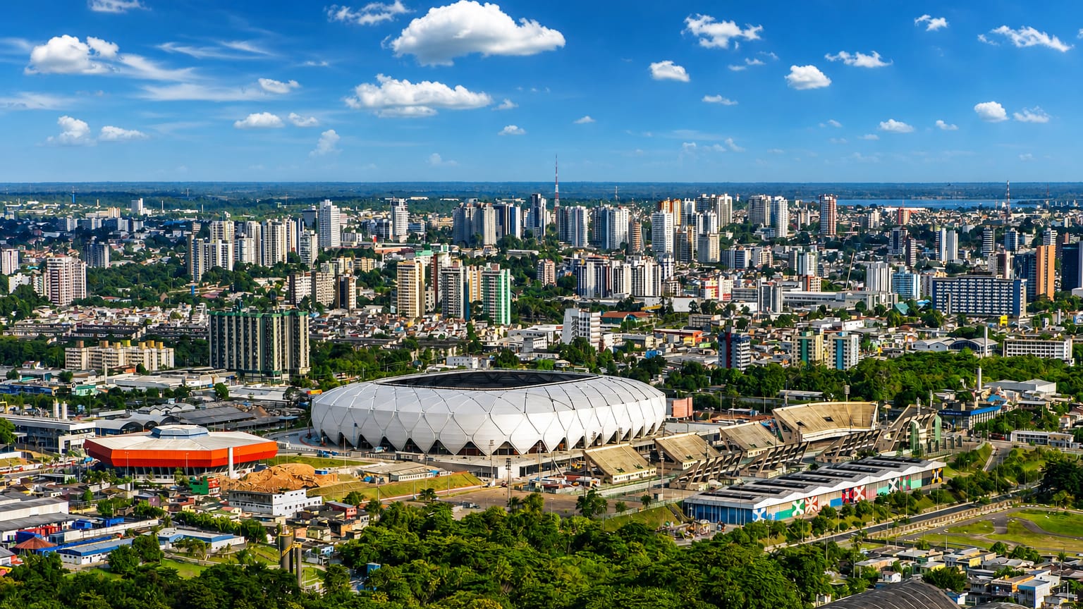 Manaus skyline with the white lattice Arena da Amazonia stadium ringed by Amazon rainforest.
