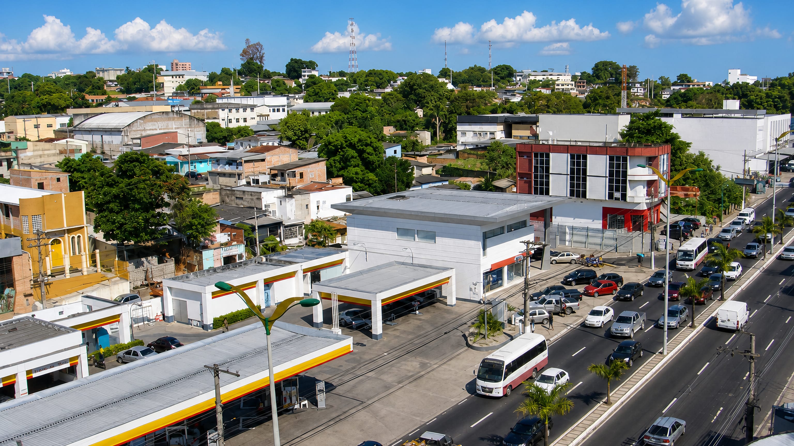 Traffic-filled avenue with a petrol station and low commercial blocks in Nossa Senhora das Graças, Manaus.