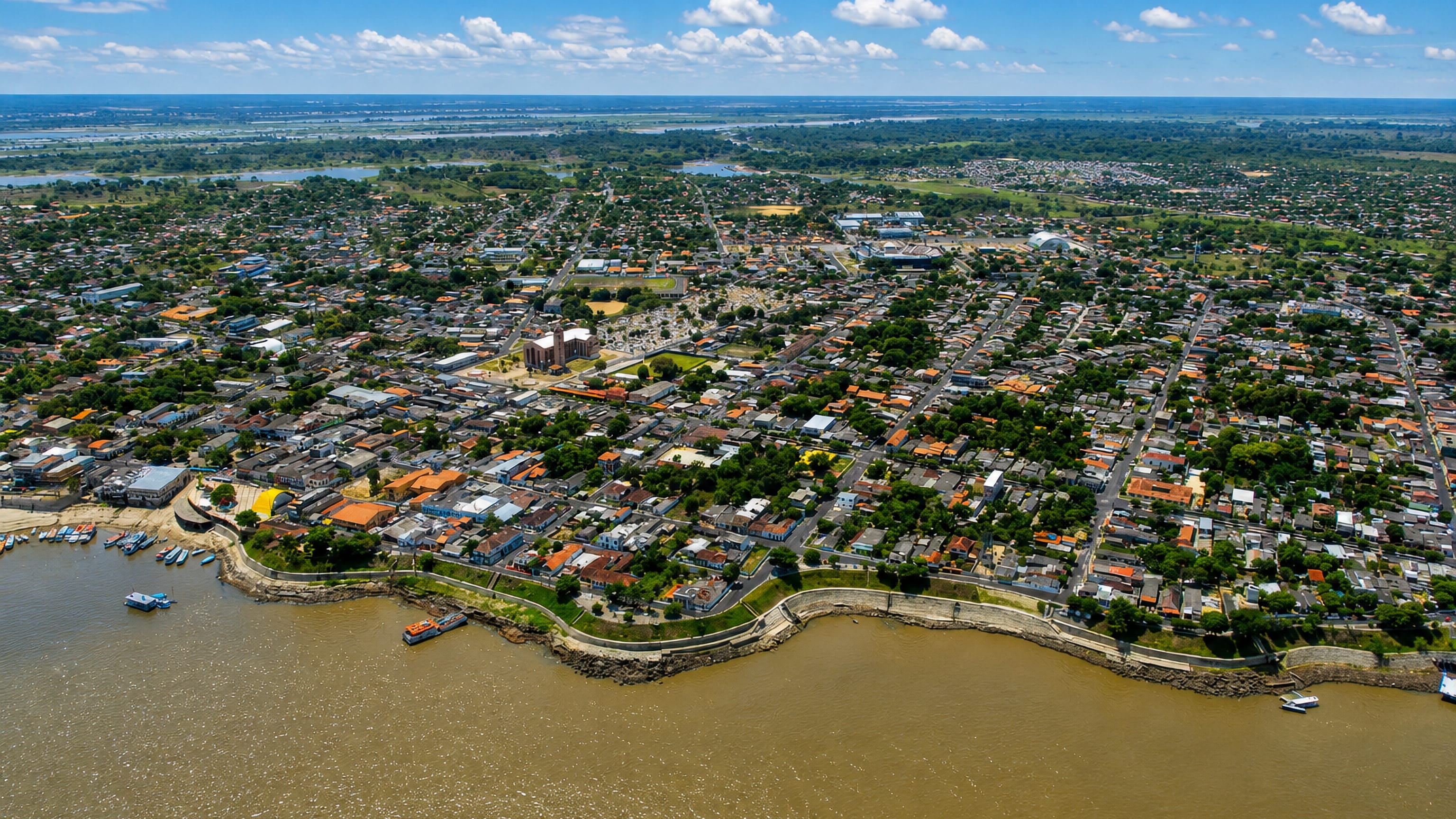 Aerial view of Parintins, Brazil, on the Amazon riverfront with its cathedral and moored boats.