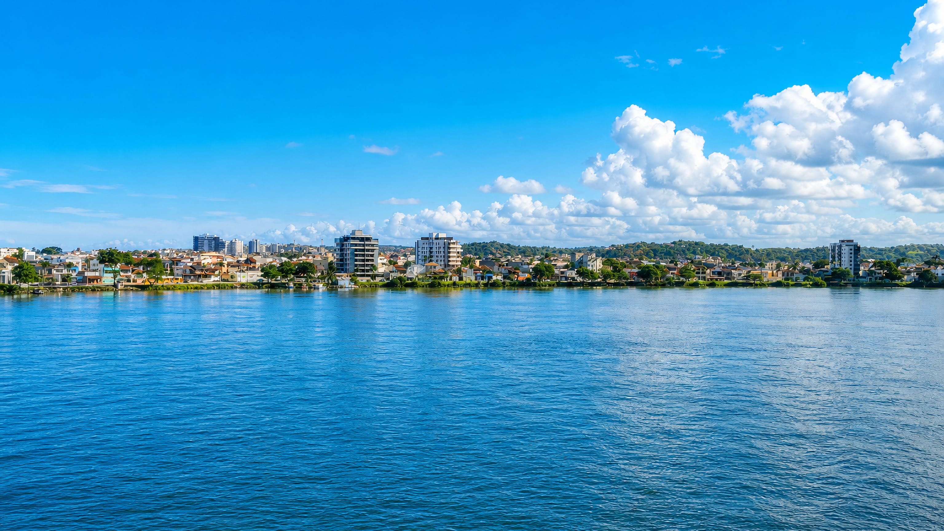 Ilhéus seen across open water, its low waterfront skyline stretching along the Bahia coast.