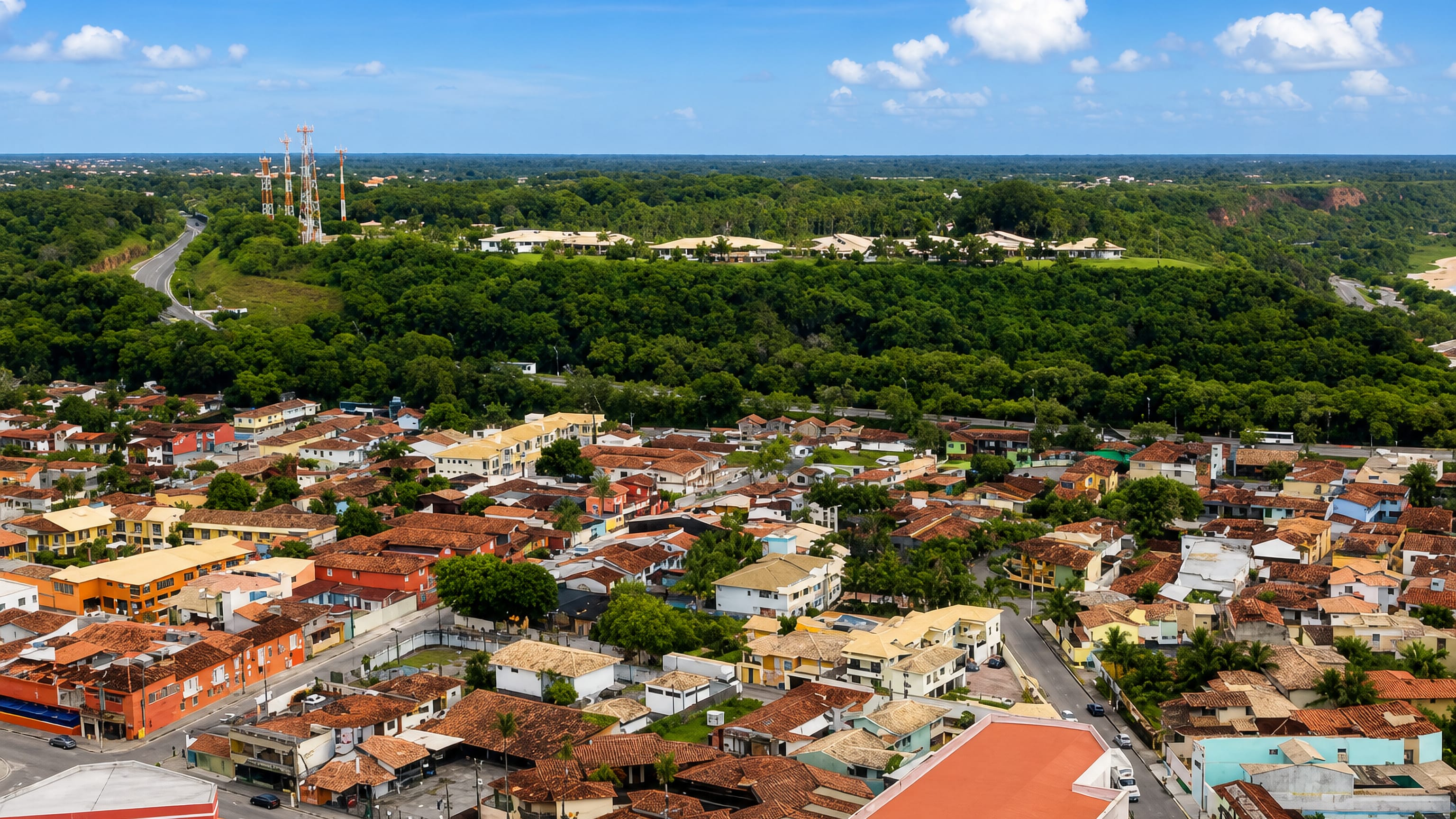 Aerial view of Porto Seguro, Brazil, showing red-tiled rooftops and colourful houses against Atlantic forest