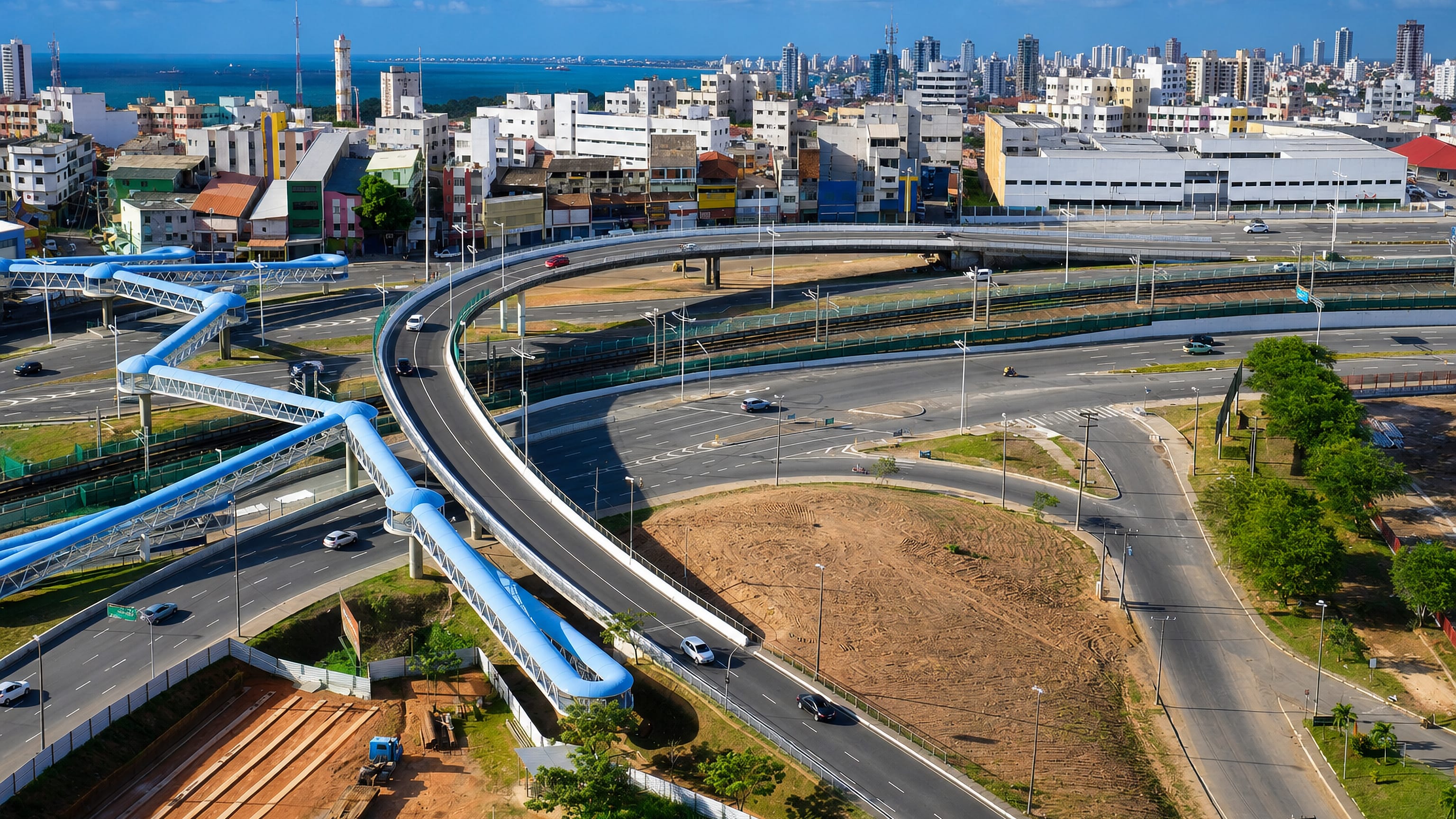 Highway interchange with blue pedestrian walkways and the Atlantic beyond at Caminho das Arvores, Salvador.