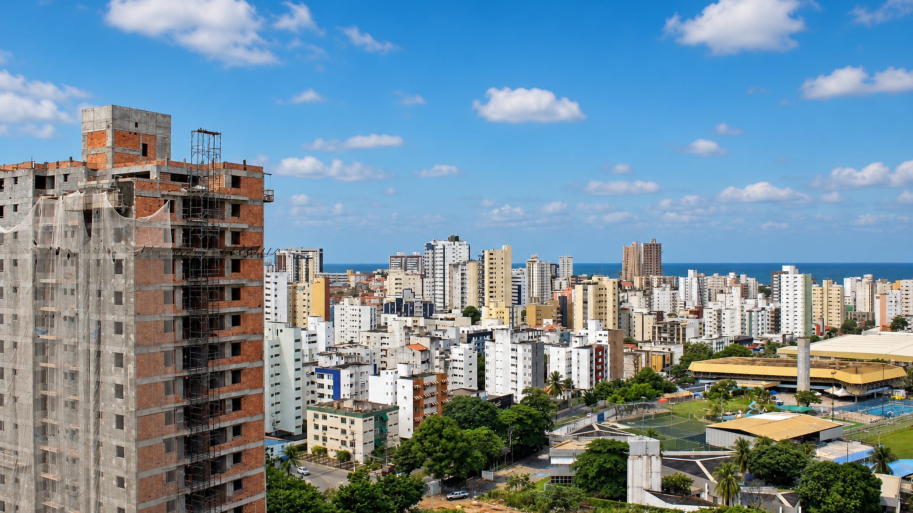 High-rise apartment towers of Costa Azul, Salvador, stretch toward the Atlantic under a bright blue sky.