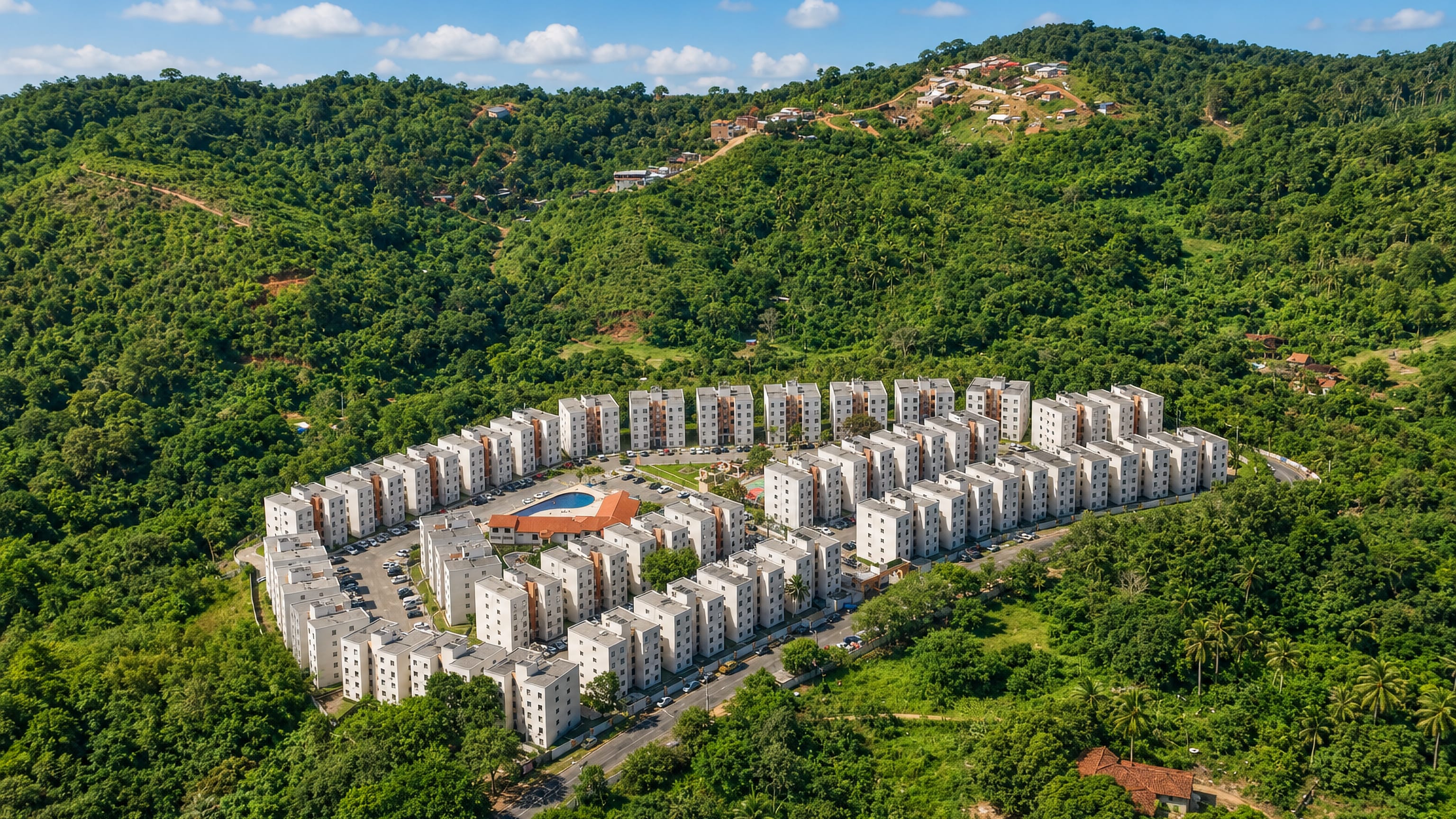 White apartment blocks ringed by forested Atlantic-forest hills near Fazenda Grande do Retiro, Salvador
