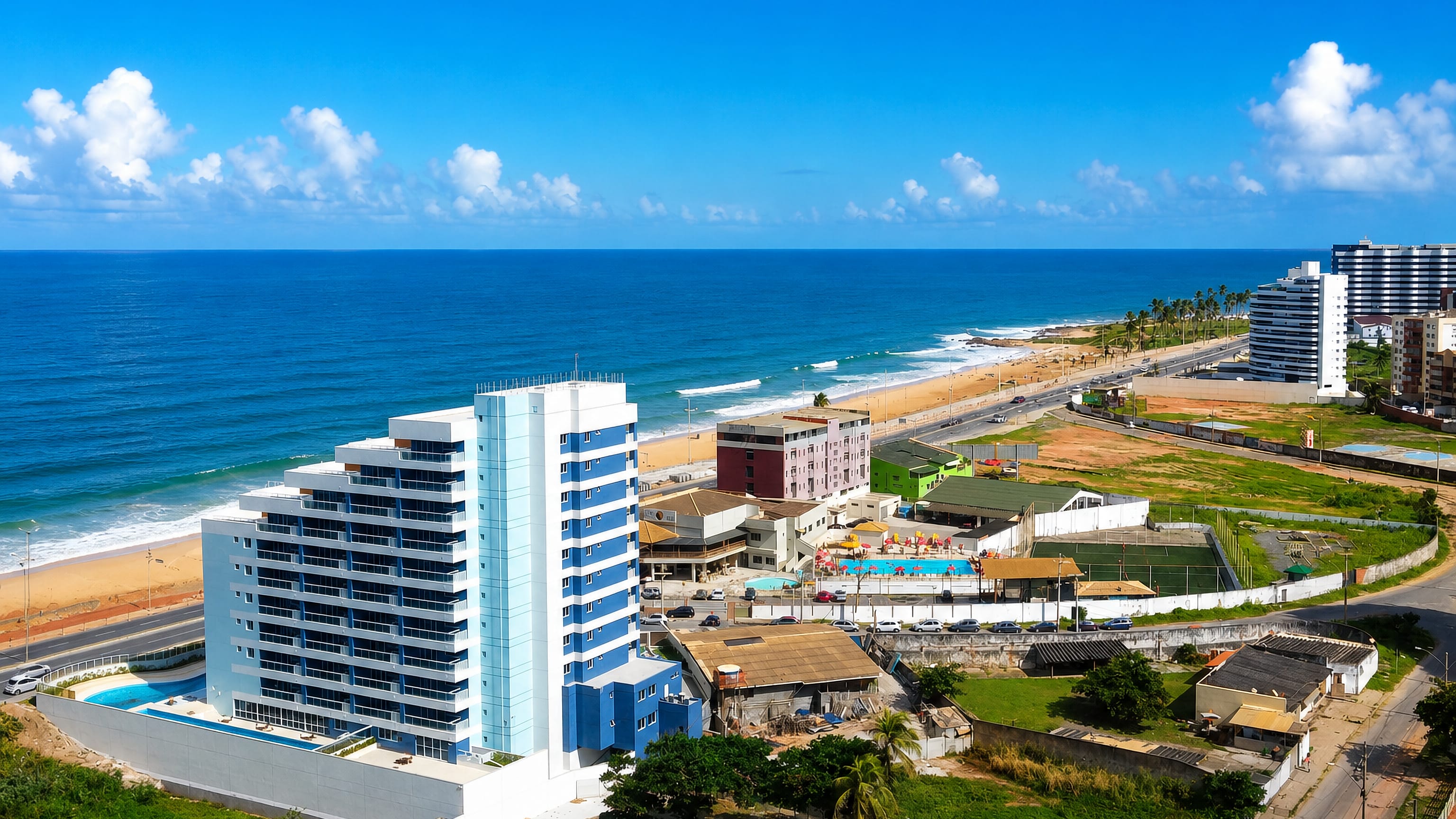 Beachfront apartment towers and low houses beside the Atlantic surf at Jardim Armacao, Salvador.