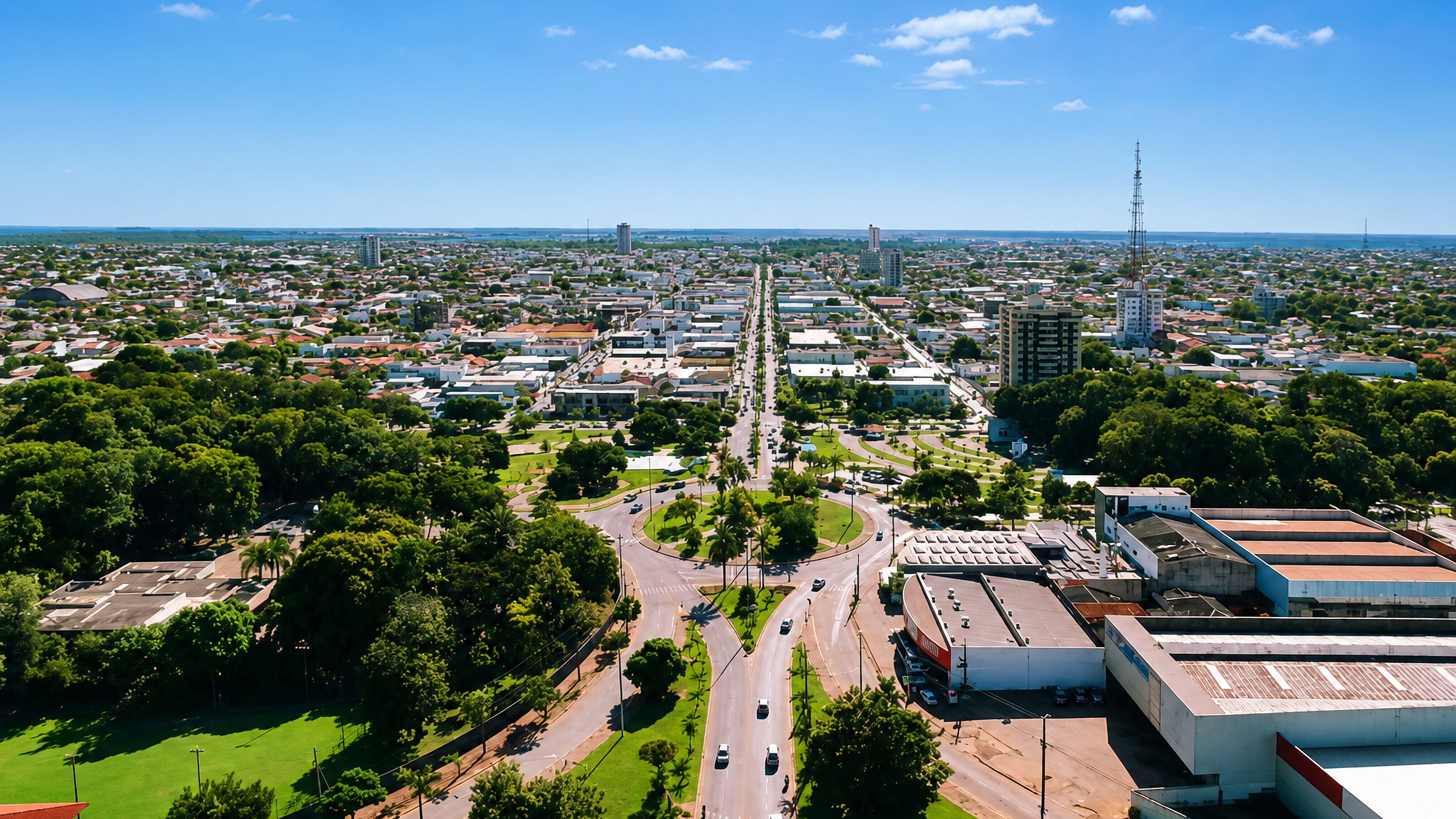 Aerial view of Sinop, Mato Grosso, with a palm-planted roundabout and wide boulevard running through the flat city.