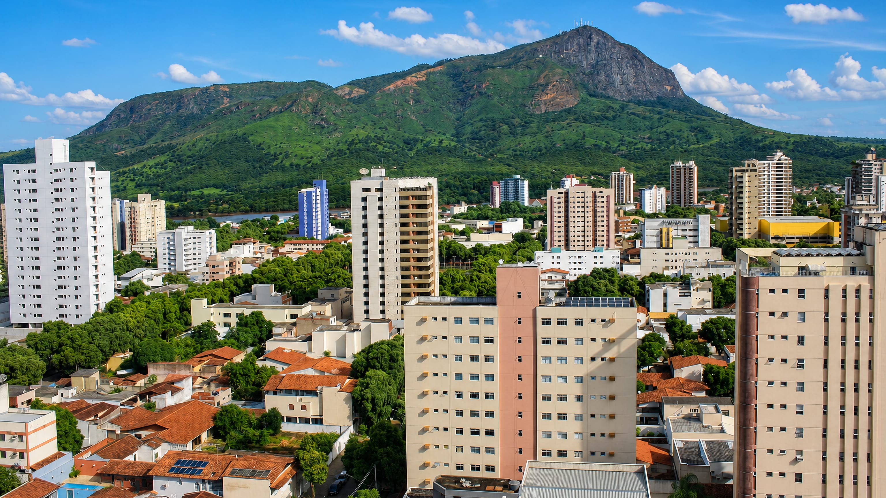 Aerial view of Governador Valadares, its apartment towers and red-tiled houses below the Ibituruna peak.