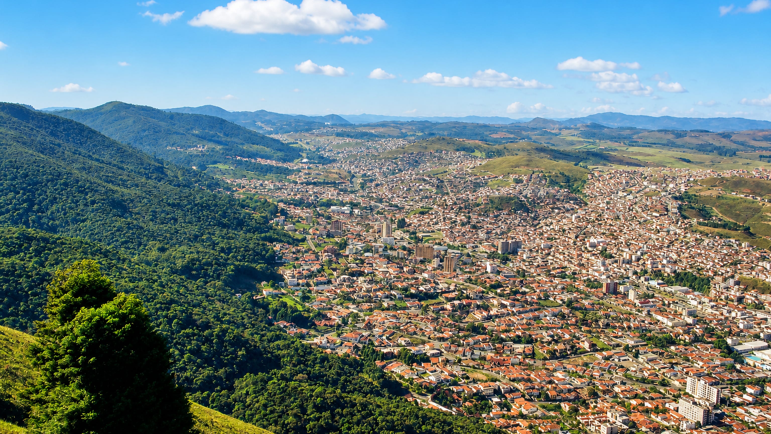 Poços de Caldas, Brazil, spread across its green mountain caldera seen from a forested ridge.