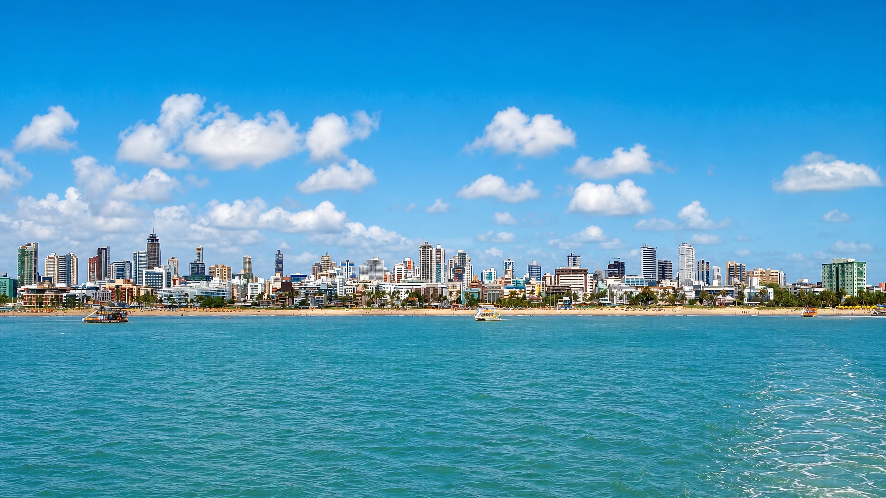 João Pessoa's beachfront skyline of highrise towers seen across turquoise water from the Atlantic.