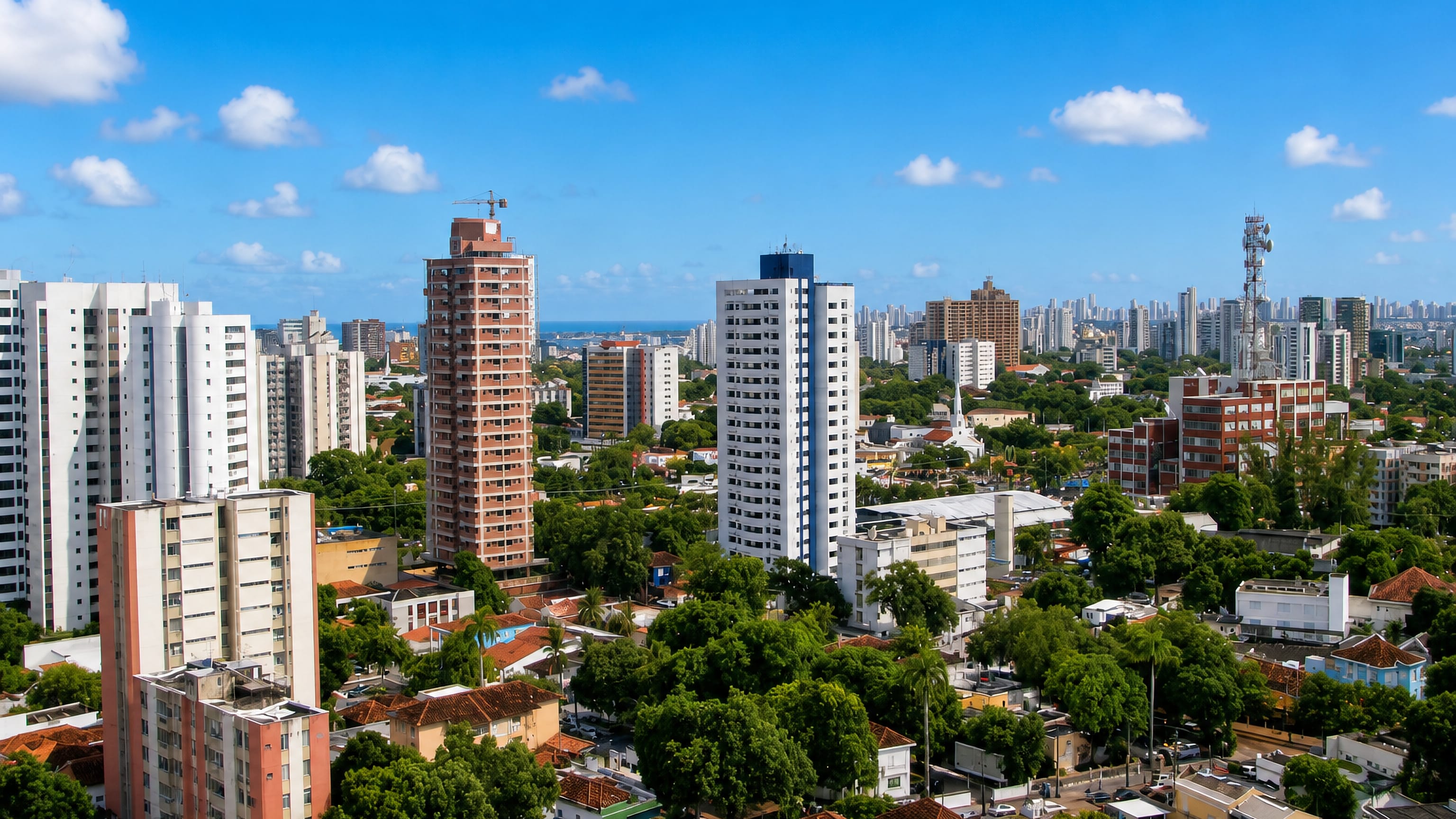 Residential towers, palms and tiled rooftops across Espinheiro in Recife, with the Atlantic beyond.