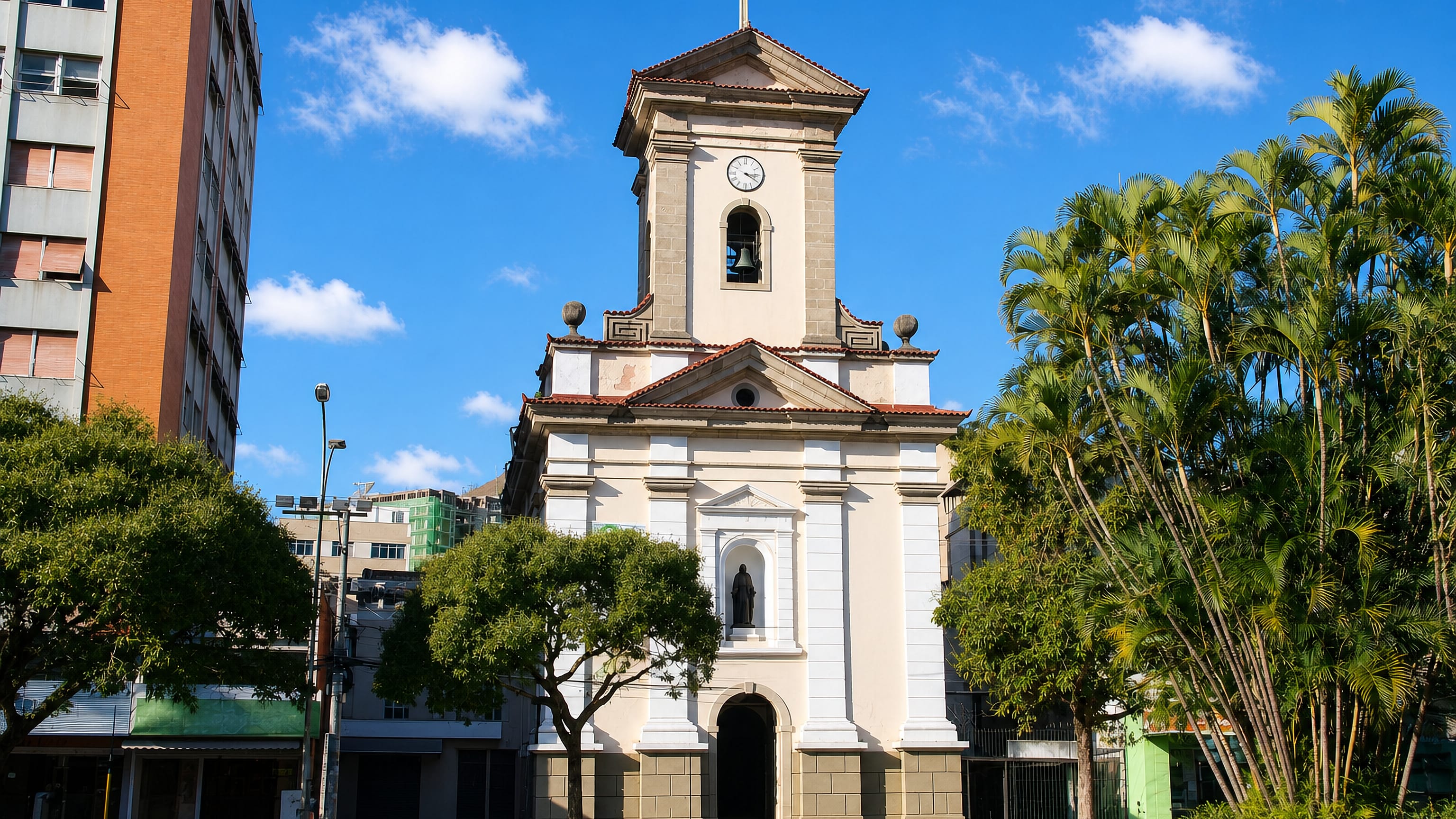The white neoclassical São João Batista cathedral on its palm-lined square in Nova Friburgo, Brazil.