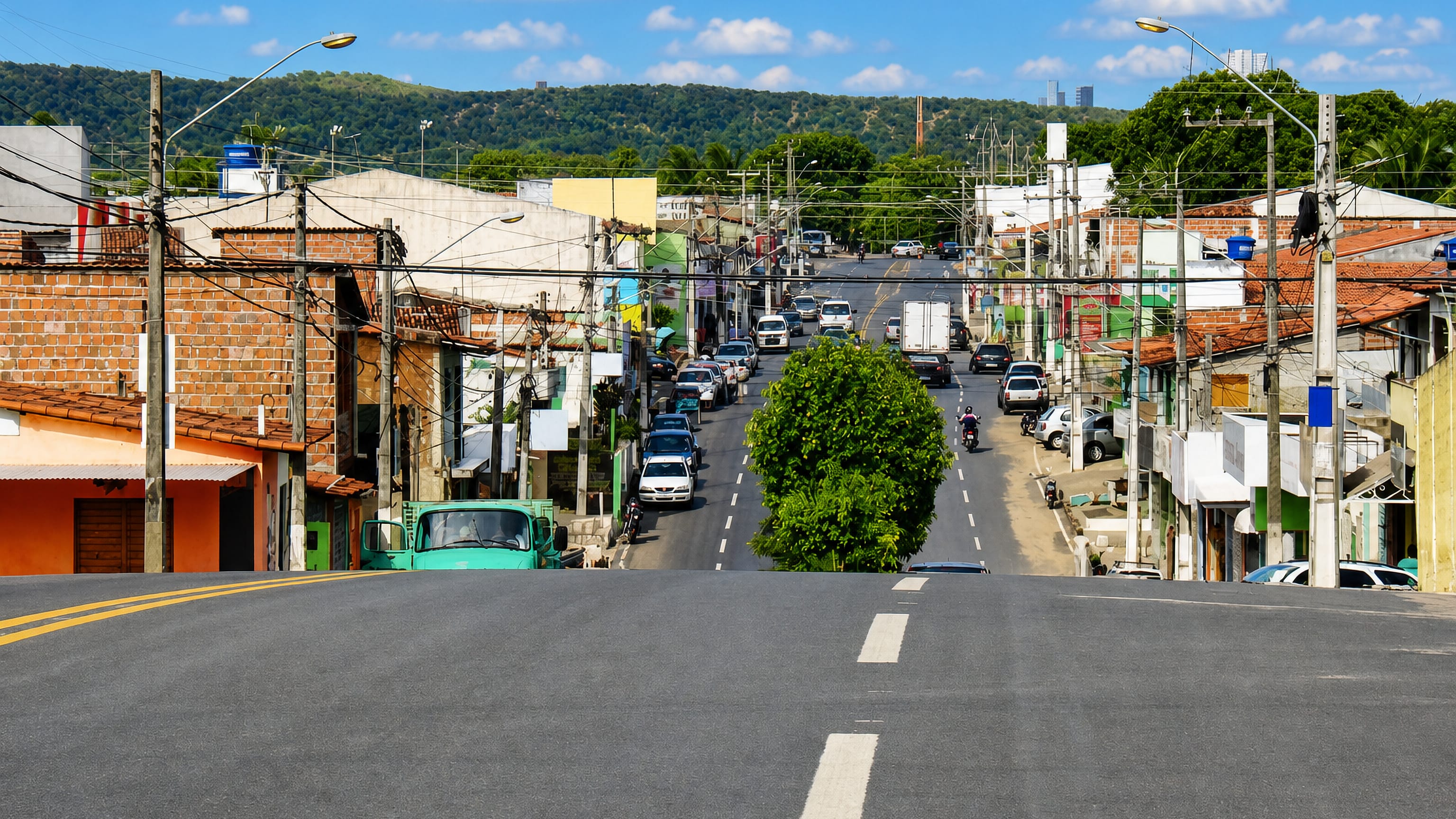 Busy hillside avenue lined with small shops and brick houses in Planalto, a bairro of Natal.