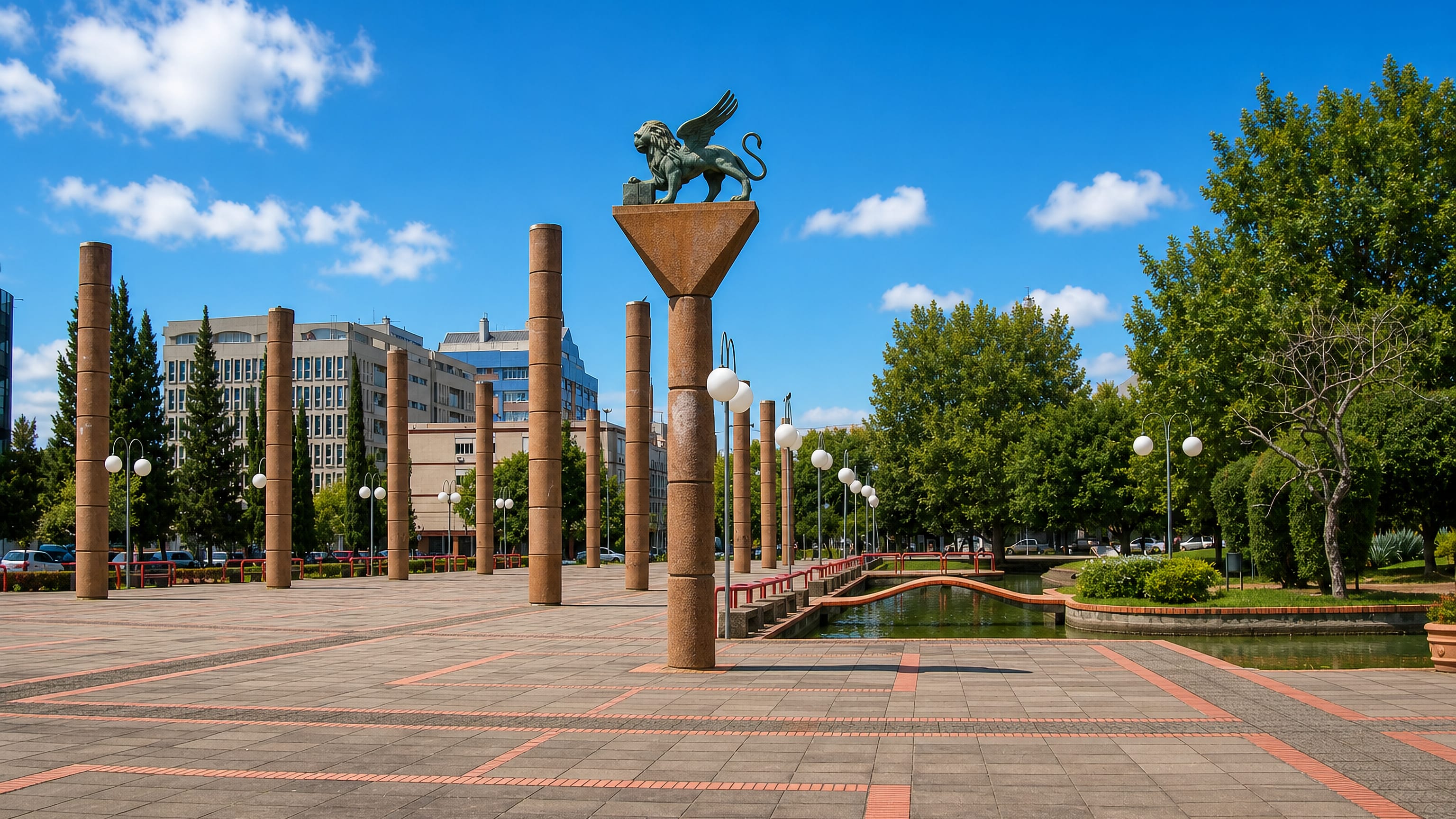 Paved civic plaza with brick columns and a water channel in Praia de Belas, Porto Alegre.