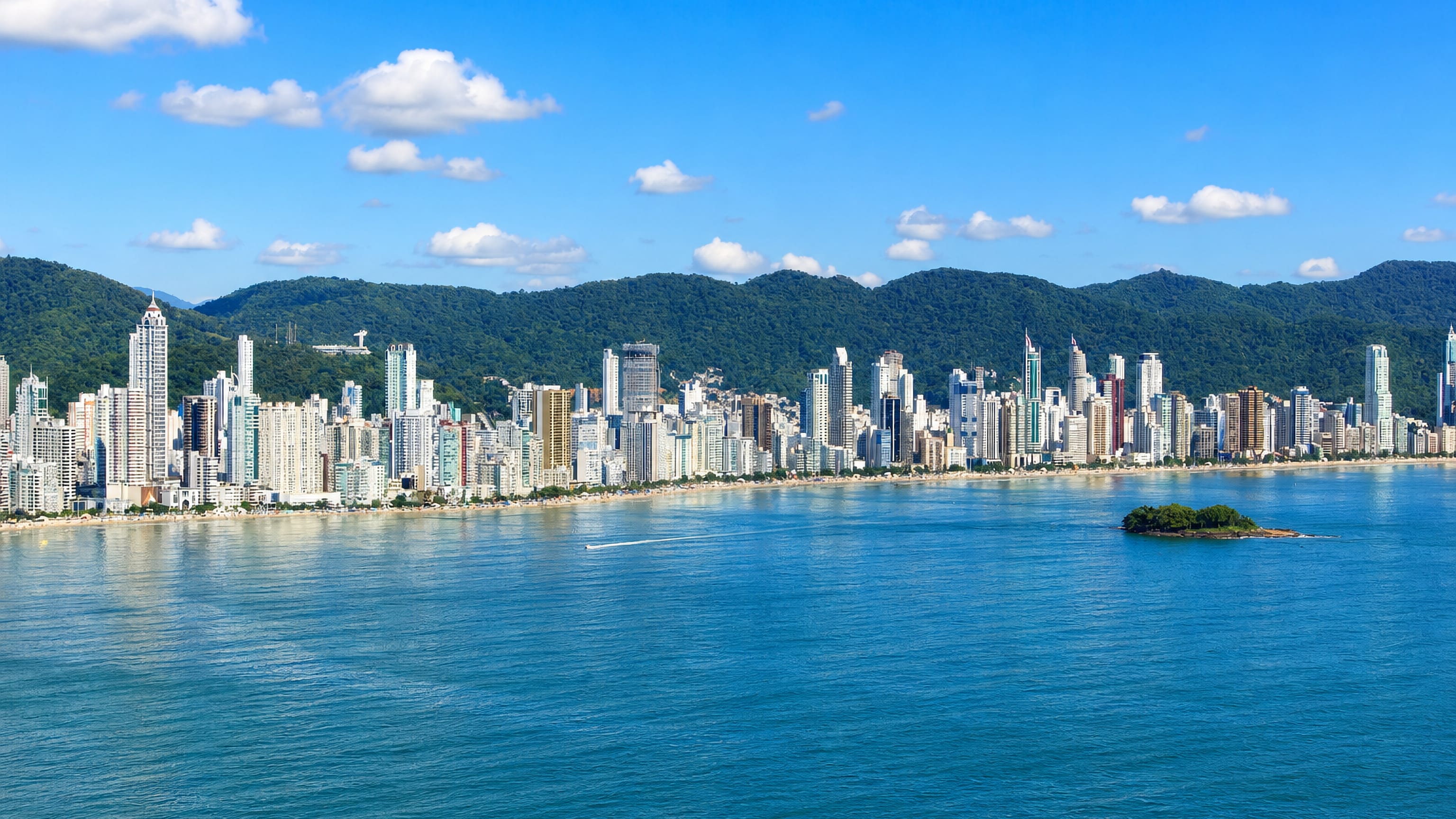 Balneario Camboriu's dense beachfront skyscrapers curving along Praia Central beneath forested hills.