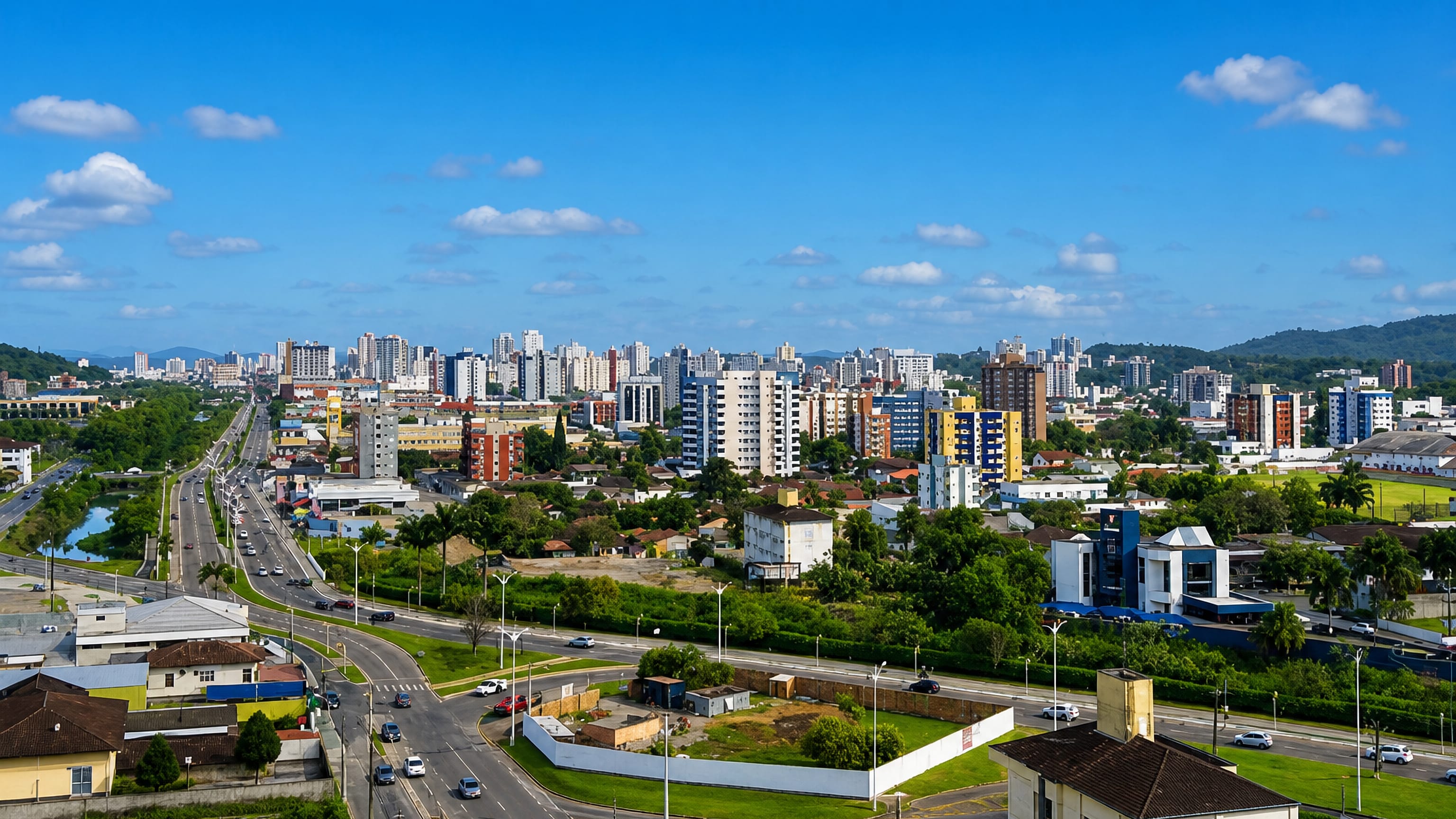 Apartment towers, a canal-lined avenue and green hills across Joinville, Santa Catarina, Brazil