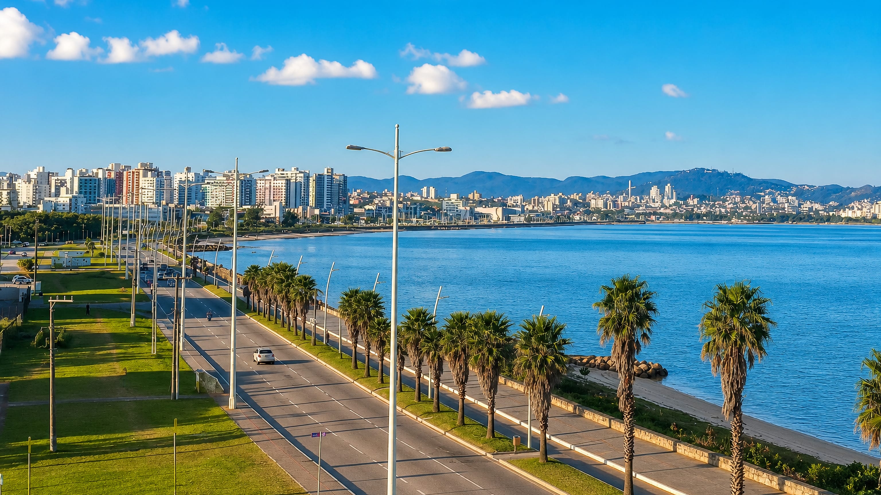 The palm-lined Beira-Mar avenue at Sao Jose, Santa Catarina, curving along the bay toward the far skyline.