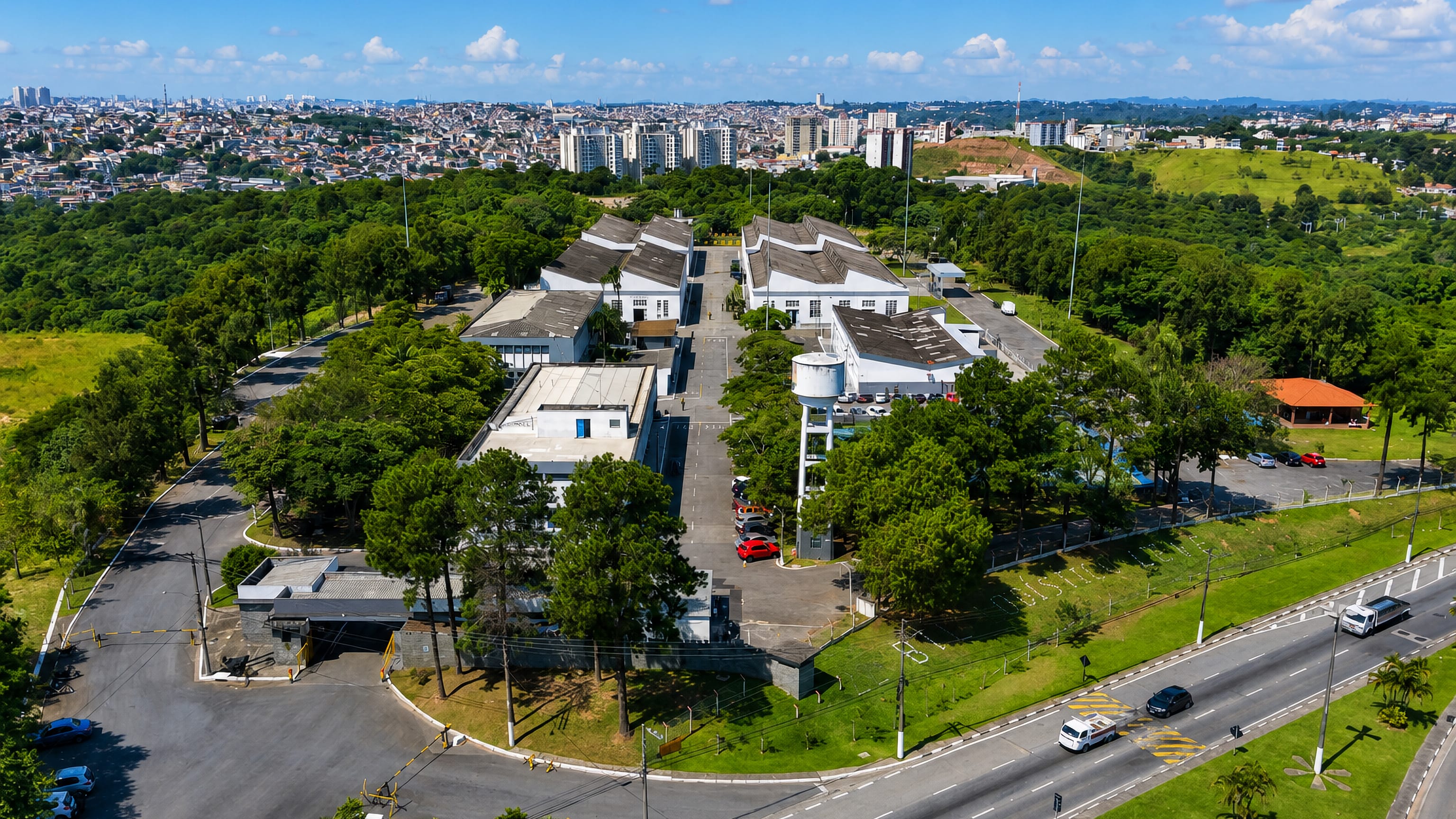 Barueri, Sao Paulo, from the air: a wooded institutional campus with the metropolitan skyline beyond