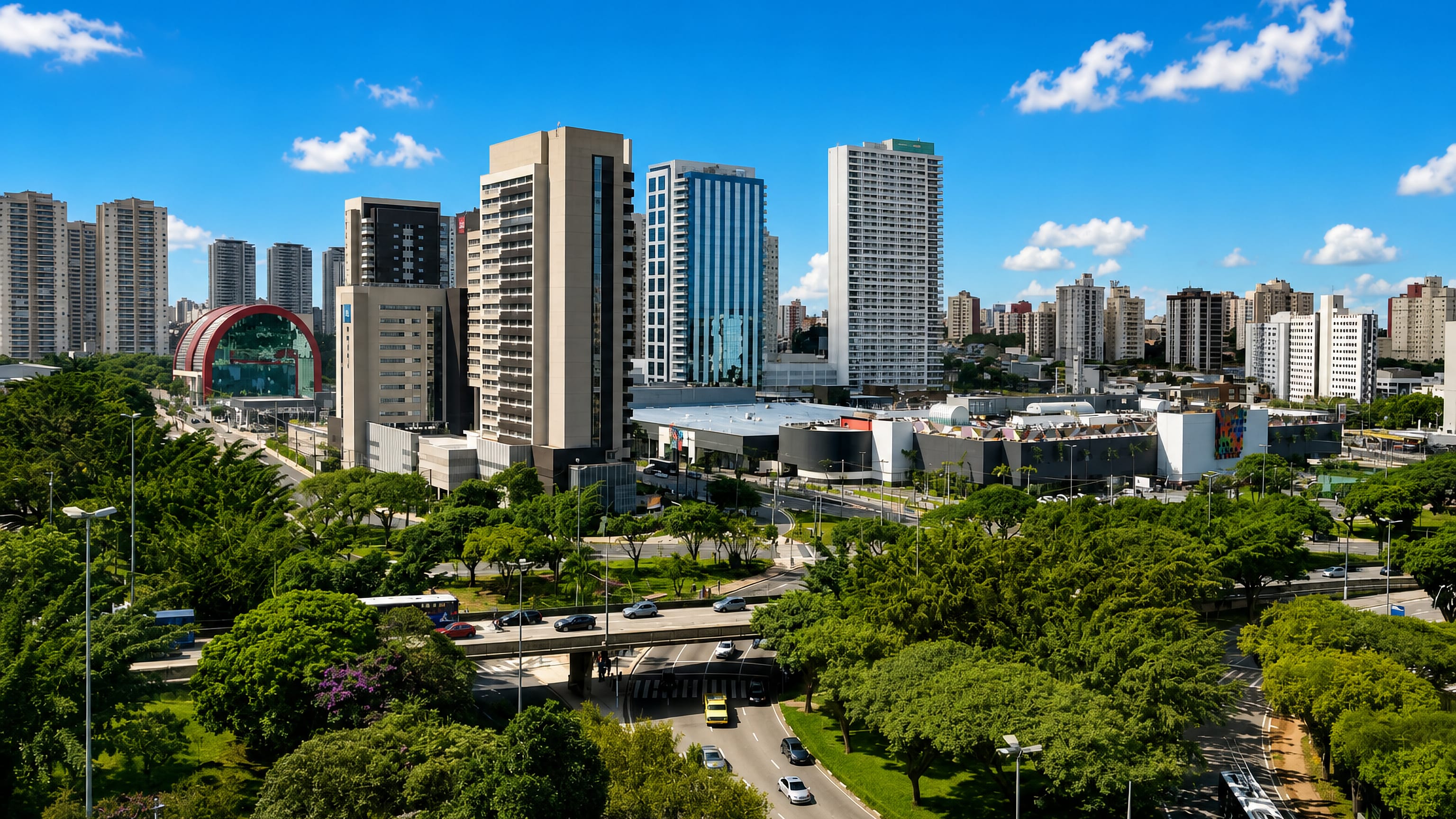 High-rise towers, a shopping centre and tree-lined avenues in central São Bernardo do Campo, Brazil, under blue sky