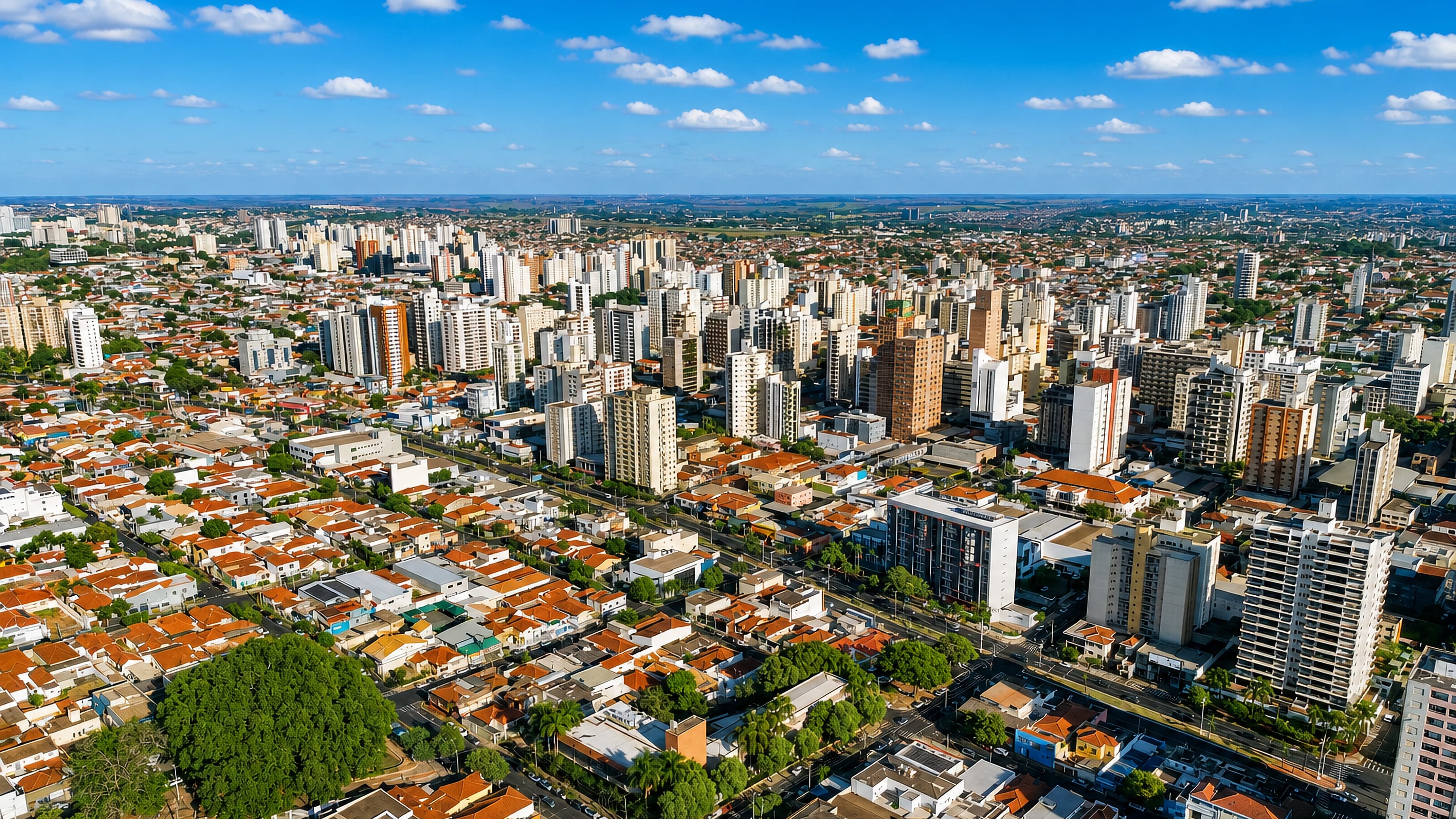 Aerial view of São José do Rio Preto's apartment towers and red-tiled houses spreading to the horizon.