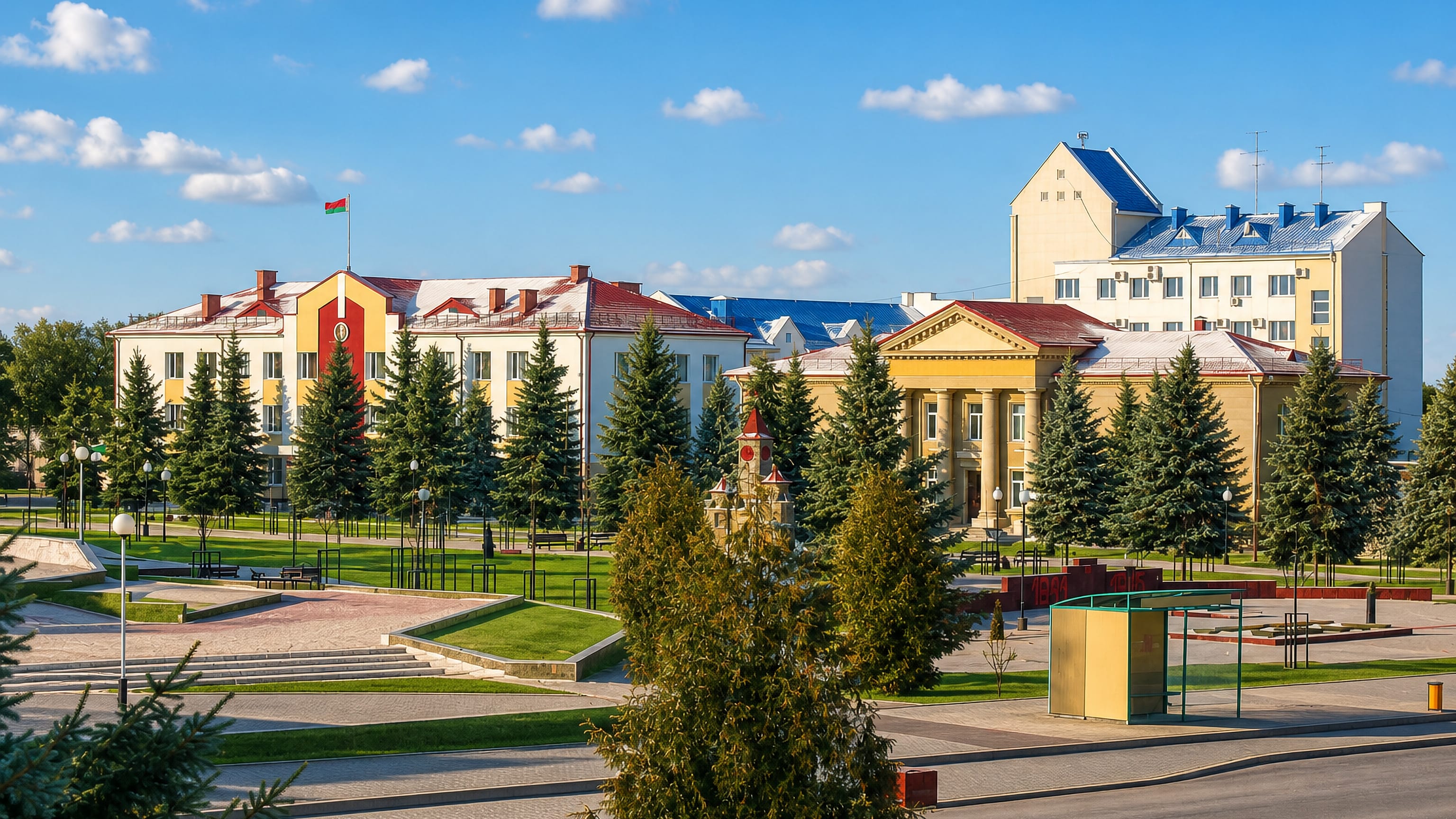 Rechytsa's yellow administrative buildings and flag face a spruce-lined civic square in southern Belarus.