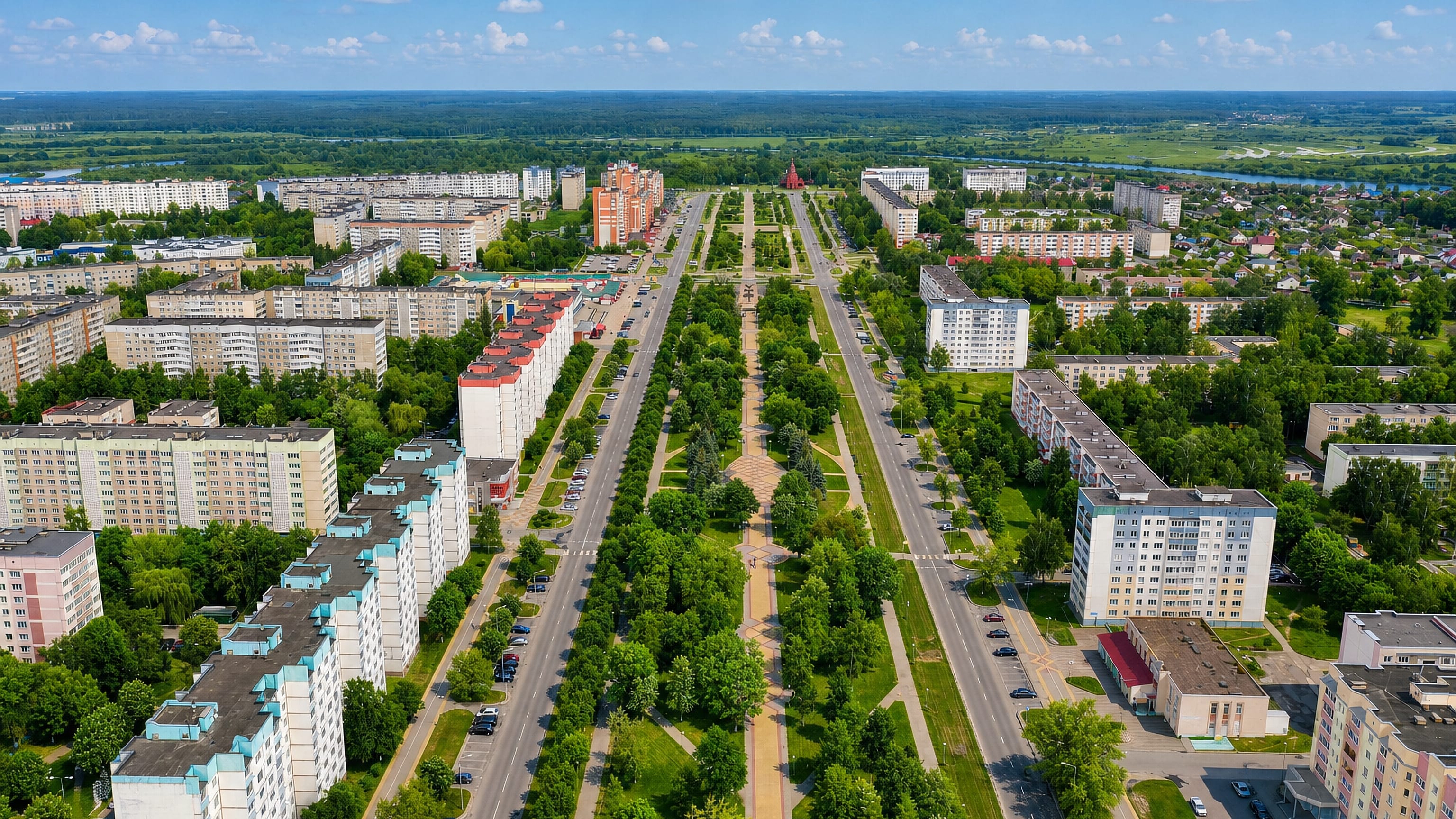 Aerial view of Zhlobin, Belarus, its central boulevard lined with trees and Soviet-era apartment blocks.