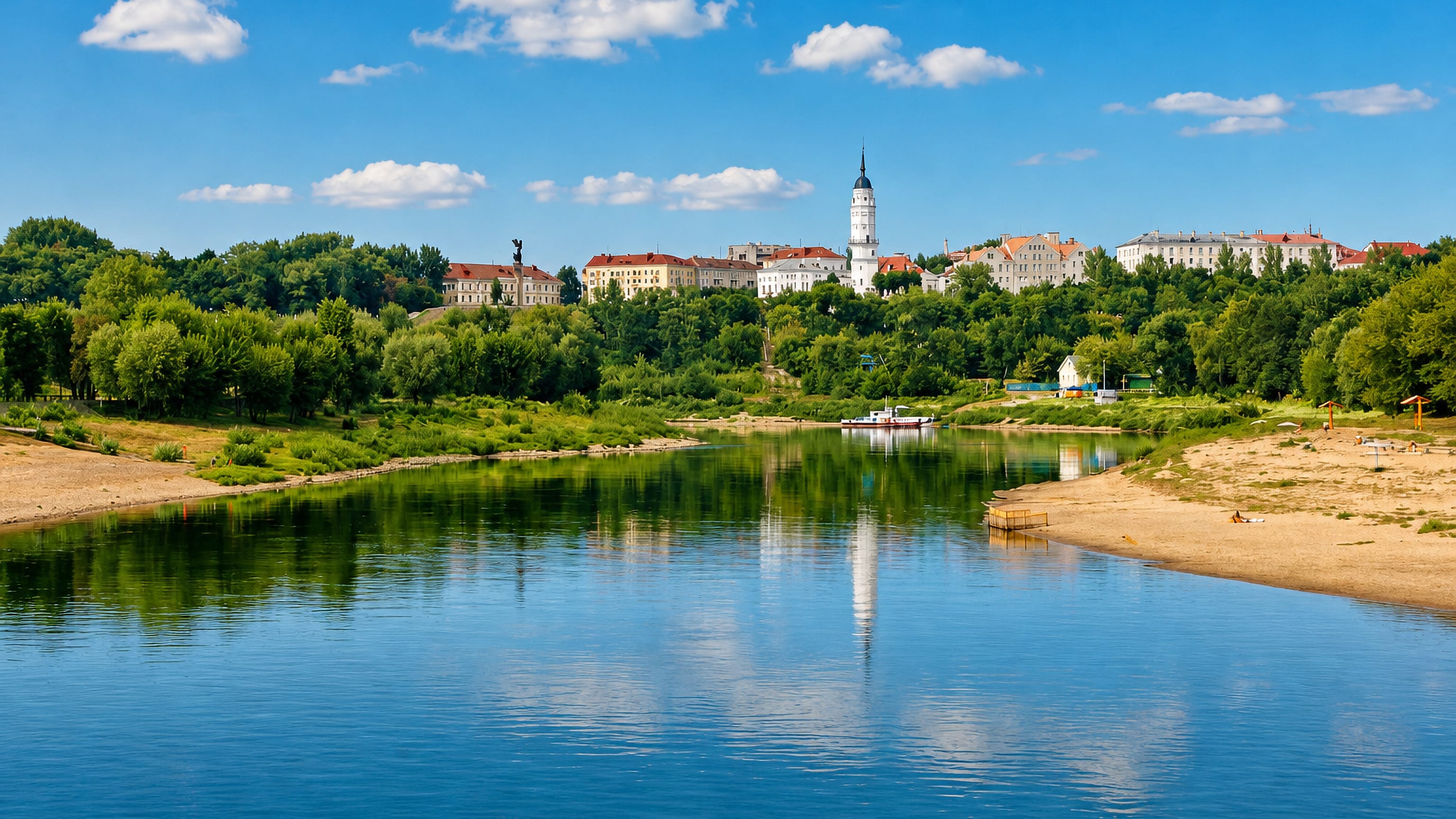 Mahilyow's town hall tower rising above the wooded bluff and the Dnieper river on a clear summer day.