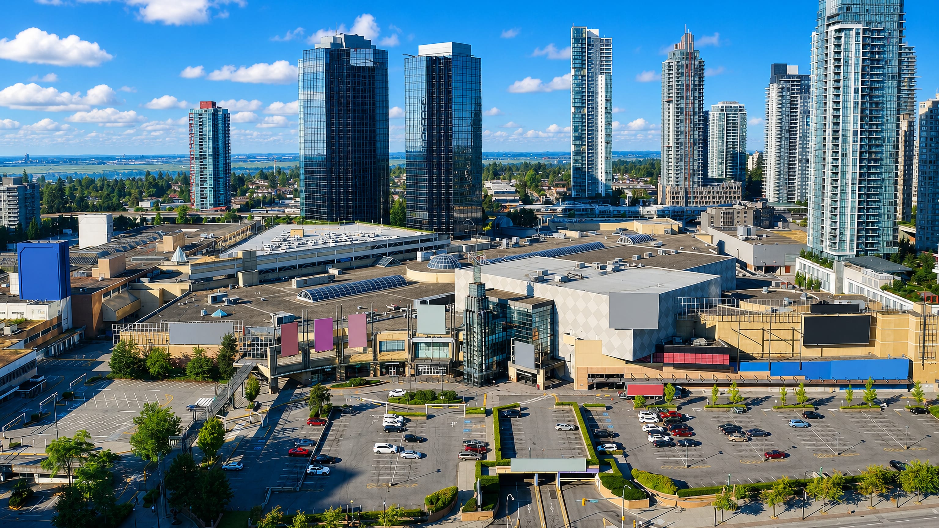 Metrotown's shopping centre and glass condo towers rising above parking lots in Burnaby, British Columbia.