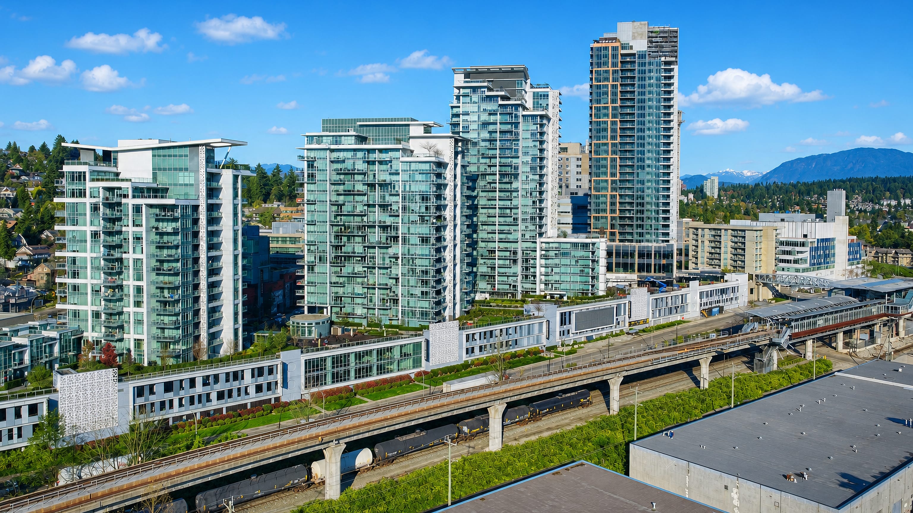 Glass condo towers beside the elevated SkyTrain guideway and station in Sapperton, New Westminster.