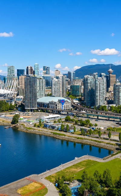 Vancouver skyline with BC Place stadium and False Creek boats below the North Shore mountains and a Canadian flag.