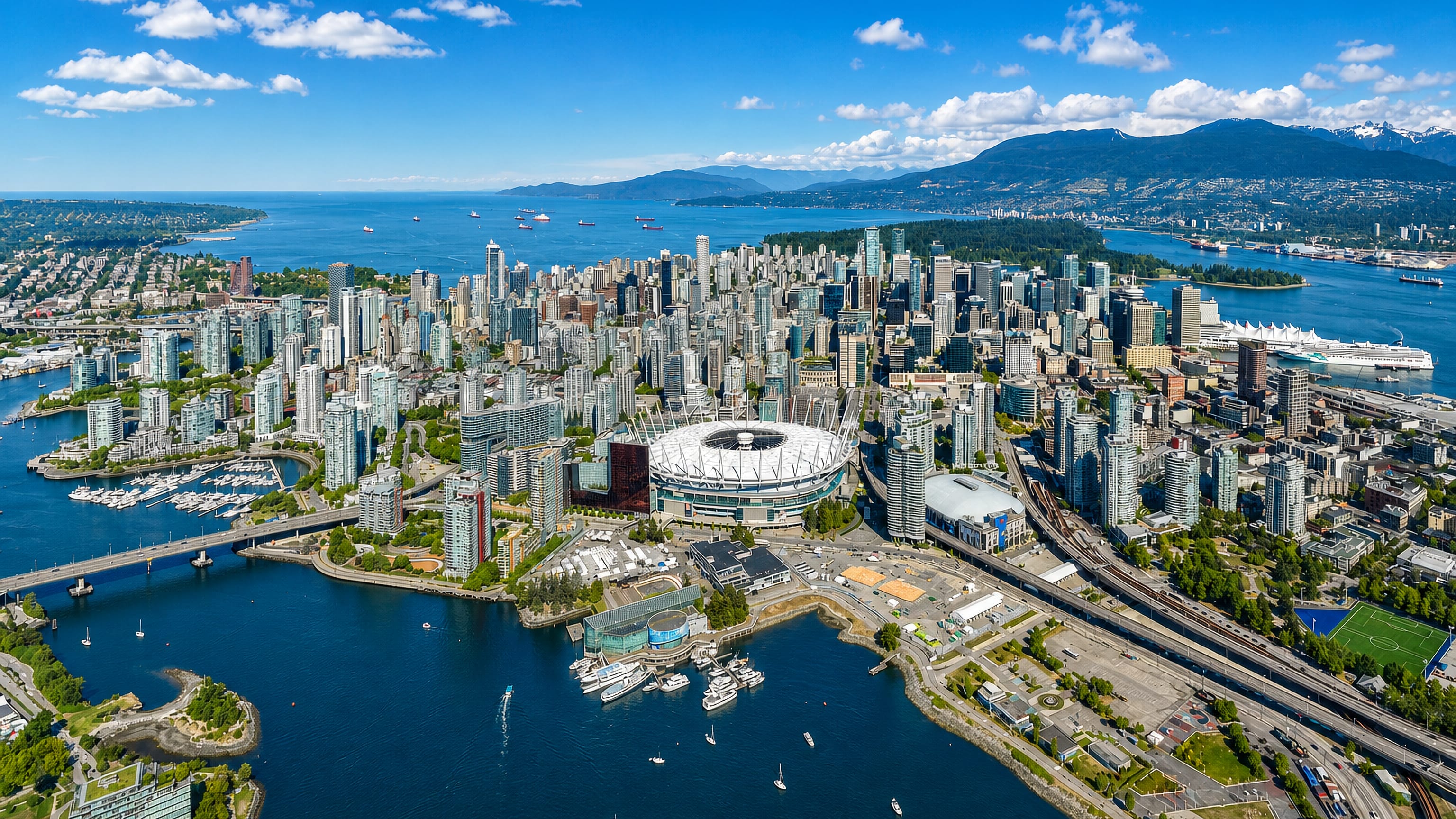 Aerial view of Downtown Vancouver with BC Place, False Creek, Coal Harbour and the North Shore mountains.