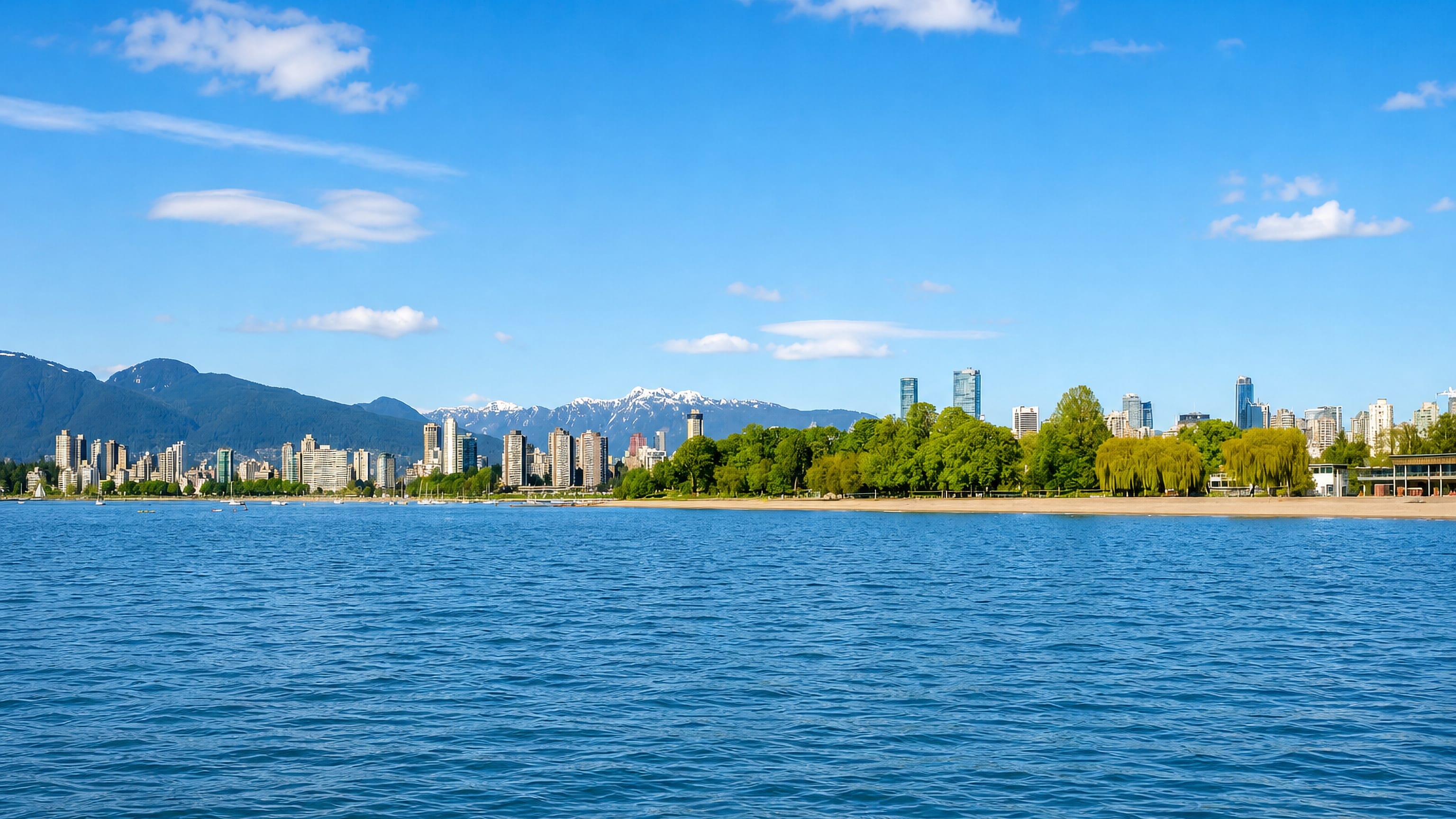 Kitsilano beachfront, English Bay and the Vancouver skyline backed by the snow-capped North Shore Mountains