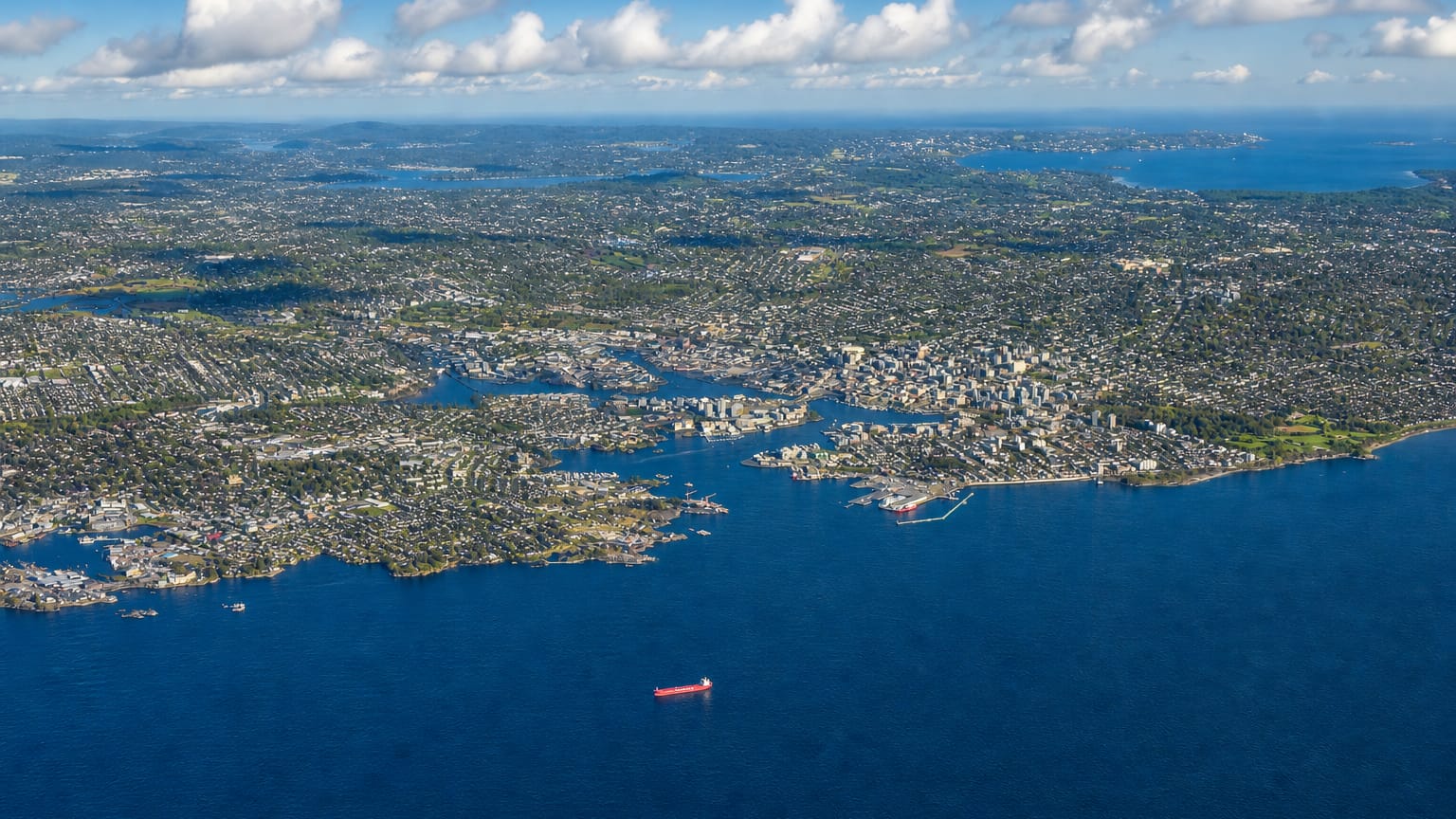 High aerial view of the coastal city of Victoria on its peninsula with ships offshore, British Columbia