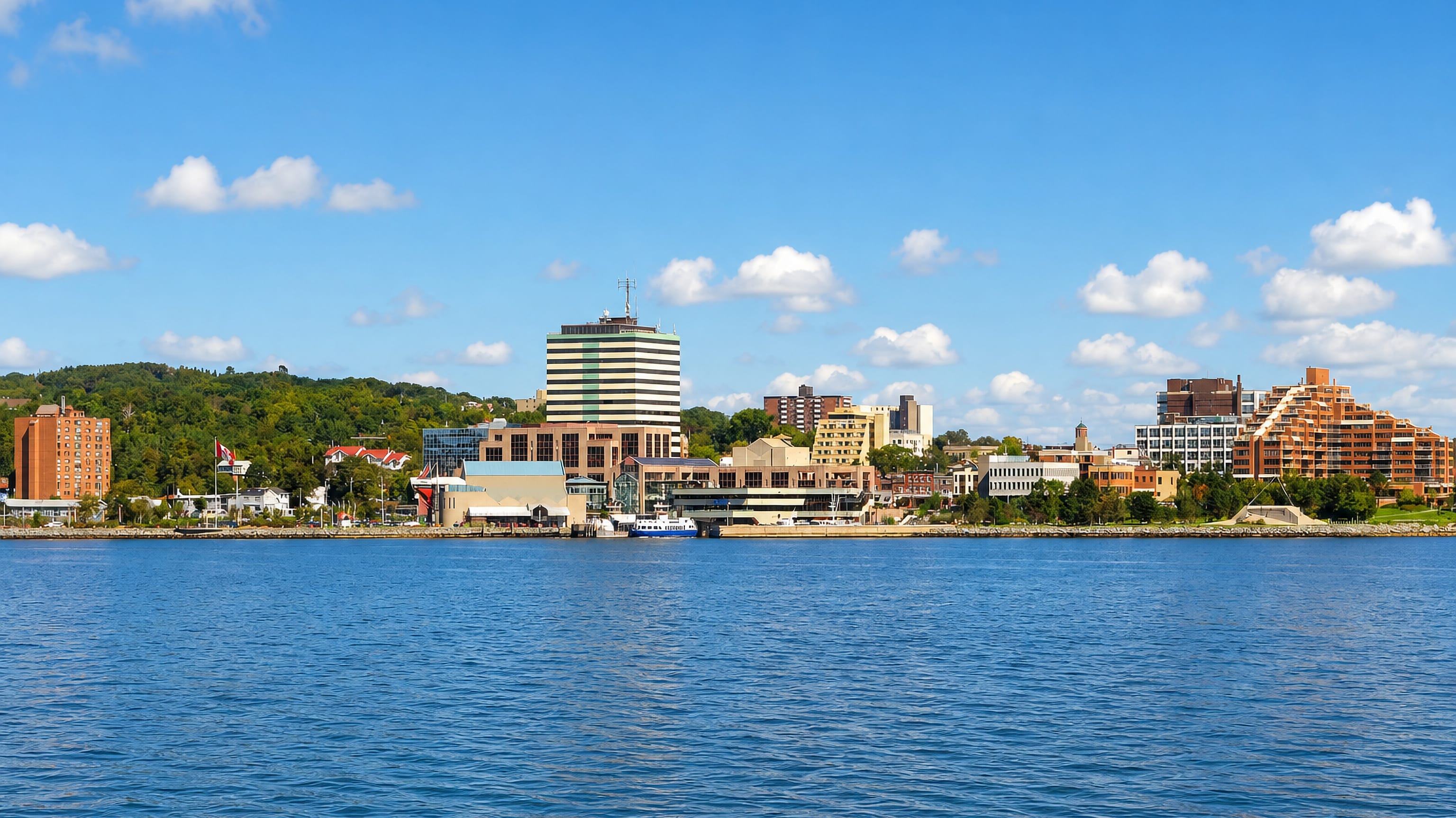 Downtown Dartmouth's waterfront, ferry berth and striped office tower seen across Halifax Harbour.