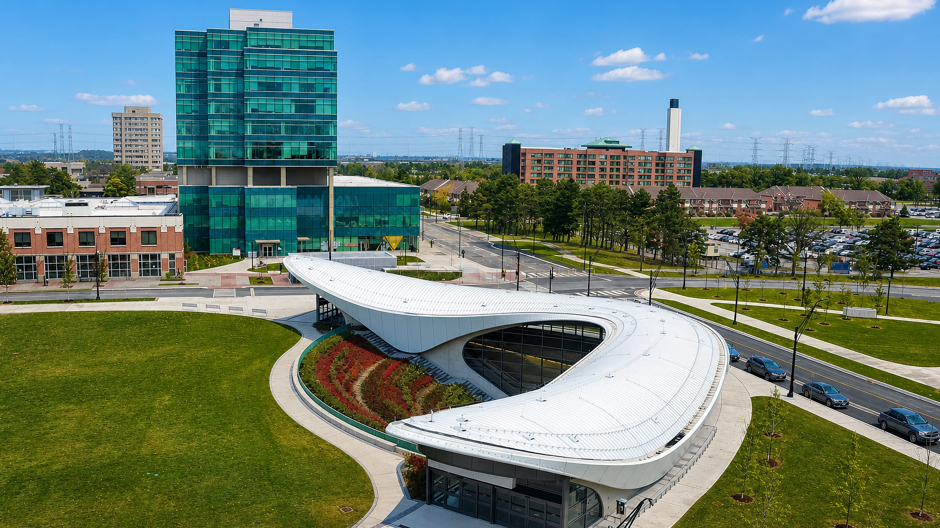 Curved white subway pavilion and green glass tower in York University Heights, Toronto.