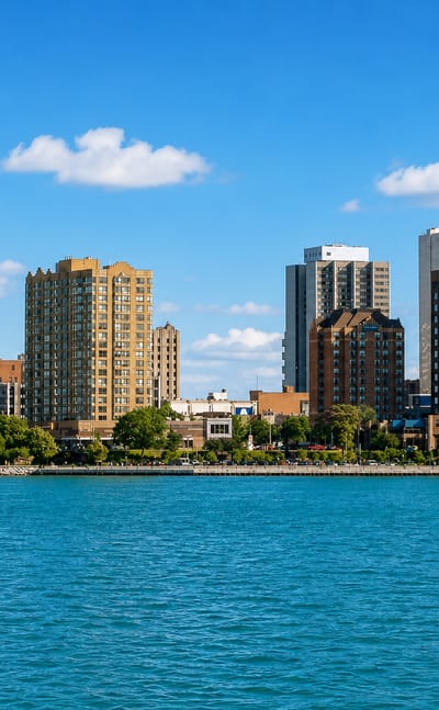 The Windsor, Ontario skyline lines the waterfront across the Detroit River on a clear day.