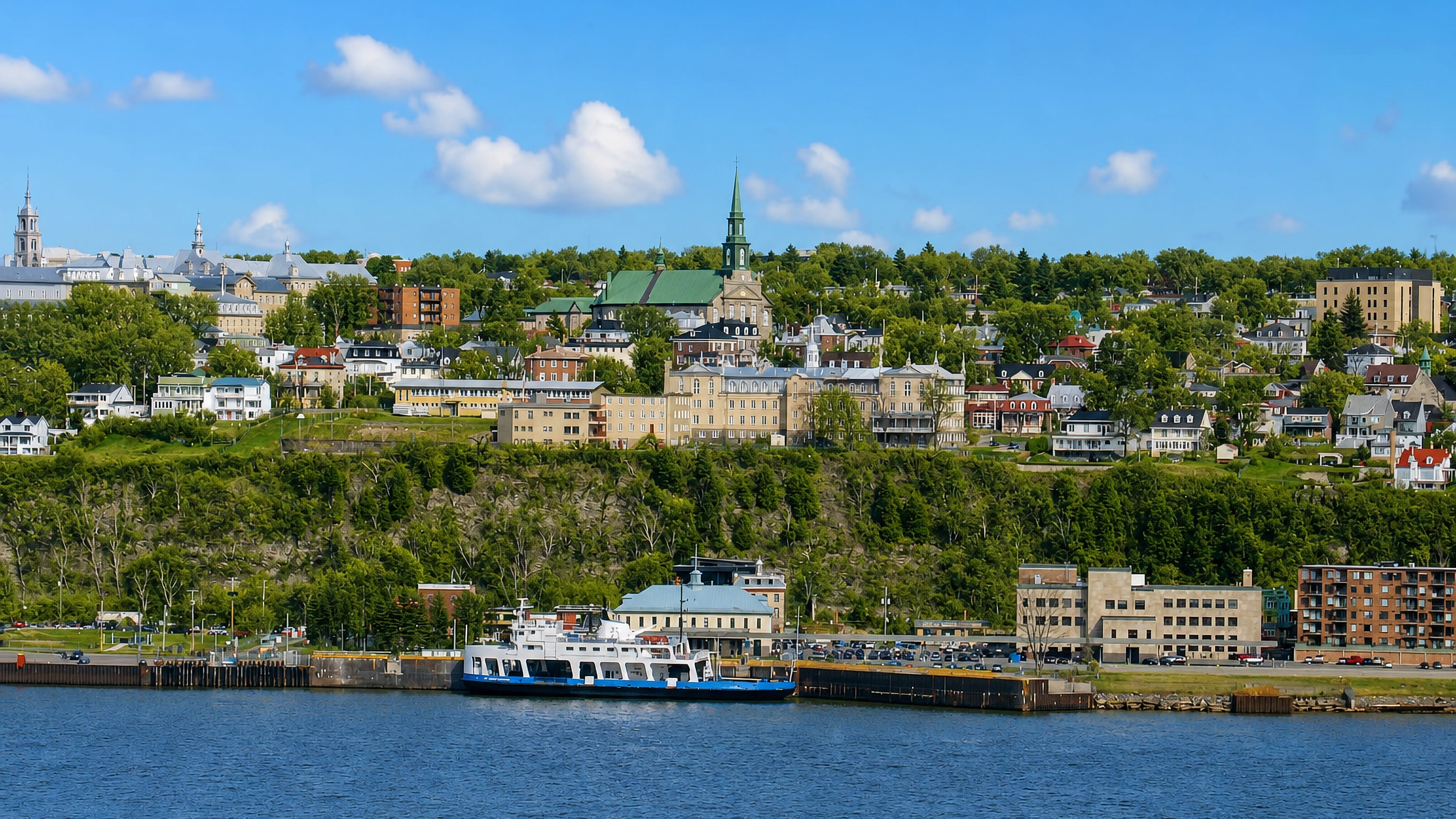 Lévis, Quebec, seen across the St. Lawrence: church spire, clifftop houses and the ferry at its terminal.