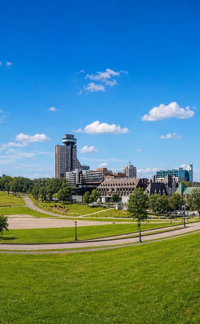 Quebec City skyline with the Marie-Guyart tower rising beyond the grassy Plains of Abraham.