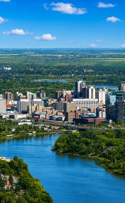 Aerial view of downtown Saskatoon along the South Saskatchewan River with prairie beyond, Canada